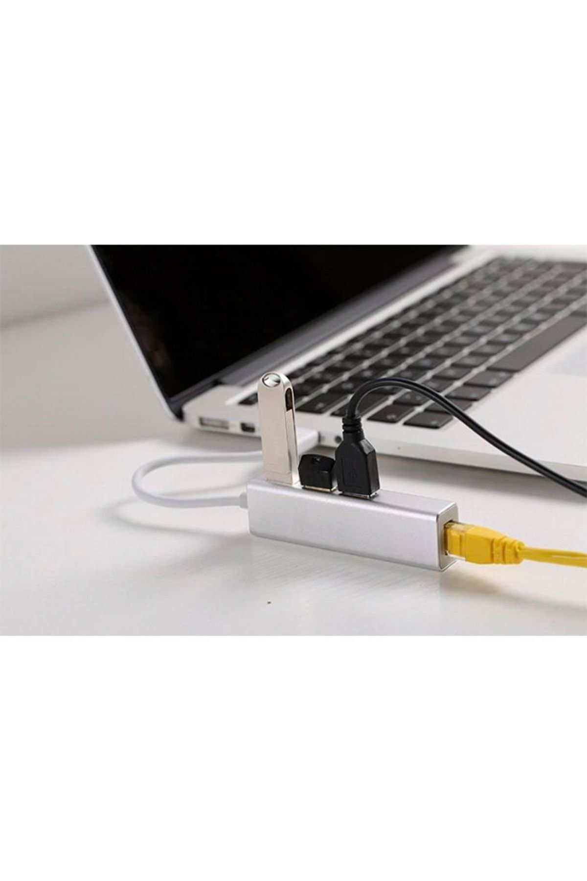 Bağlı bir USB hub'ı olan bir dizüstü bilgisayar. USB flash sürücüsü, siyah USB kablosu ve sarı ağ kablosu takılı USB hub.