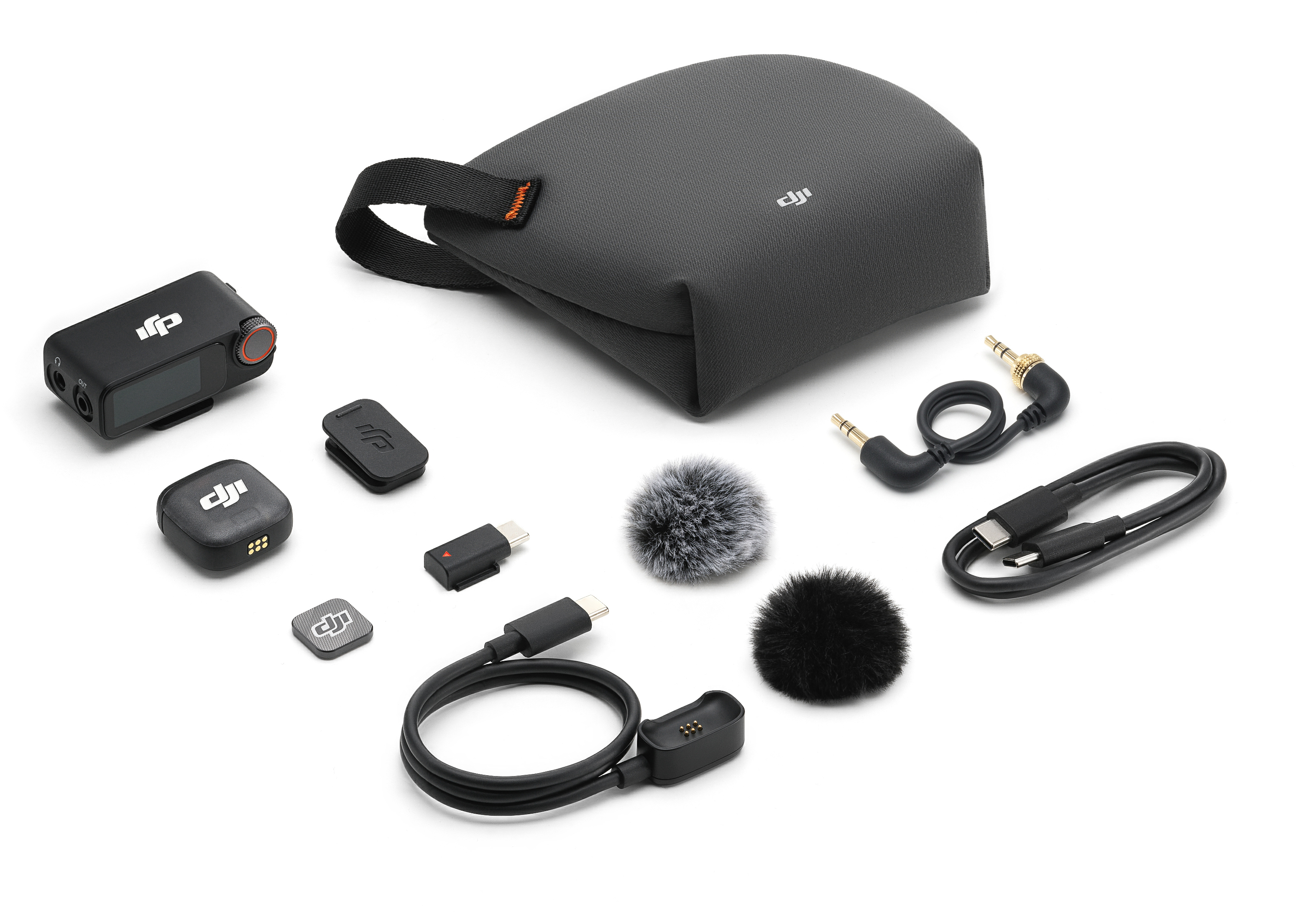 Zestaw czarnego sprzętu audio, w tym futerał, mikrofony, kable i nadajniki, ułożone na białej powierzchni.