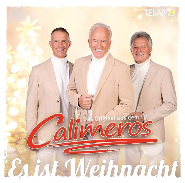 Drei Männer in Anzügen lächeln. Das Calimeros-Logo befindet sich unten mit 'Es ist Weihnacht' darunter. Weihnachtsbaum Hintergrund.