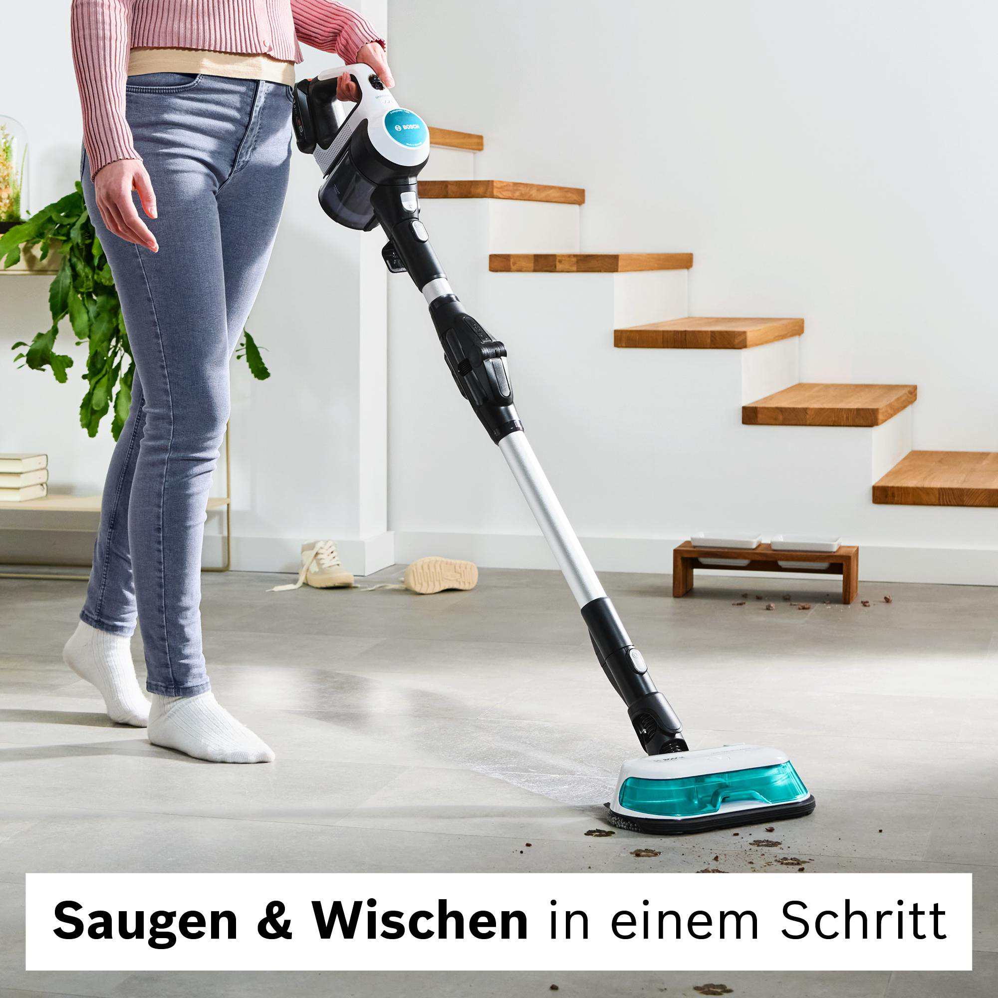 Eine Person benutzt einen Staubsauger. Im Hintergrund sind eine Treppe und ein Paar Schuhe zu sehen. Der Text lautet 'Saugen & Wischen in einem Schritt'.