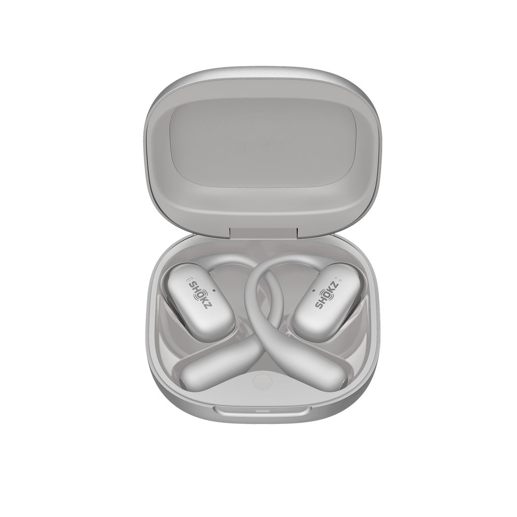 Açık bir kutuda beyaz Shokz kulaklıklar. Kutu ve kulaklıklar gümüş rengindedir. Shokz logosu kulaklıklarda bulunur.