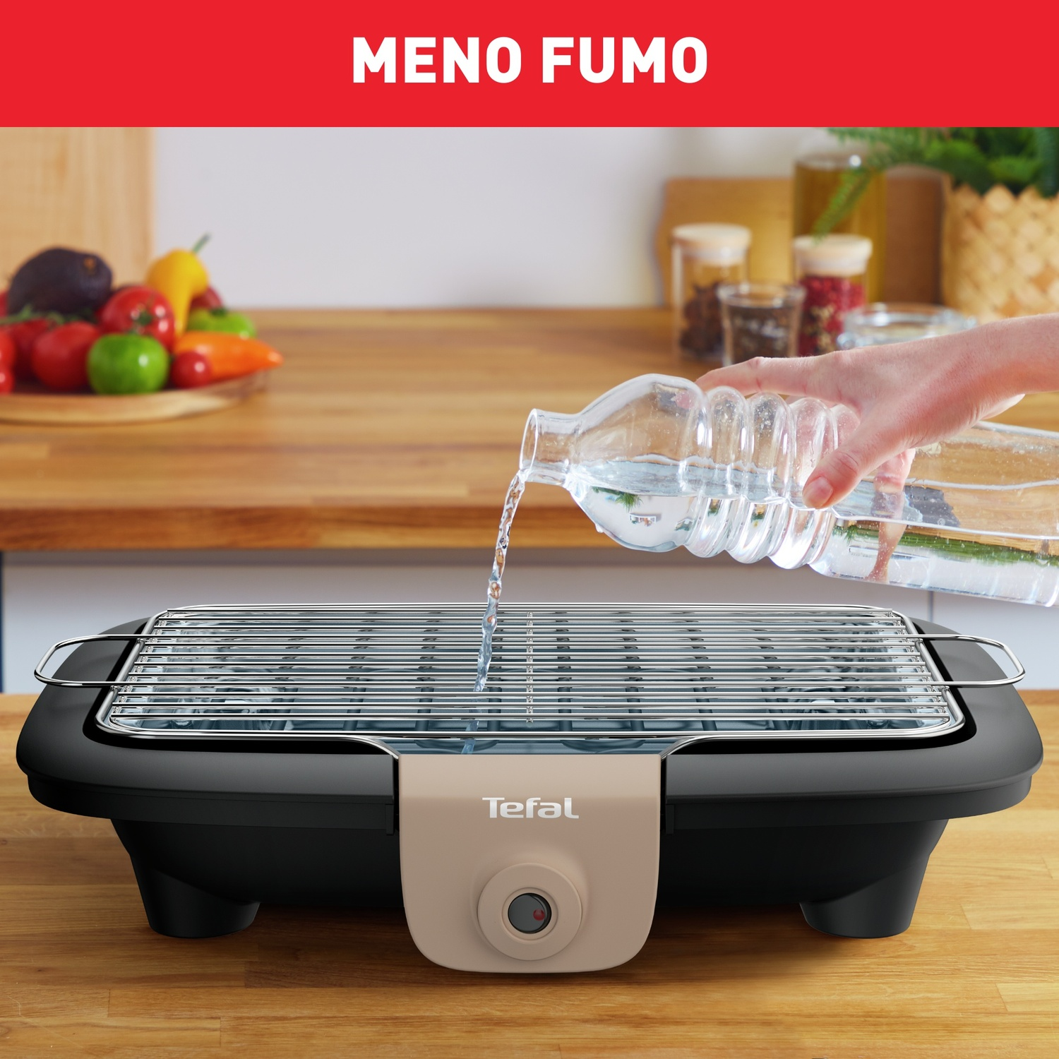 Una persona versa acqua da una bottiglia su una griglia Tefal. Verdure su una tavola di legno sullo sfondo.