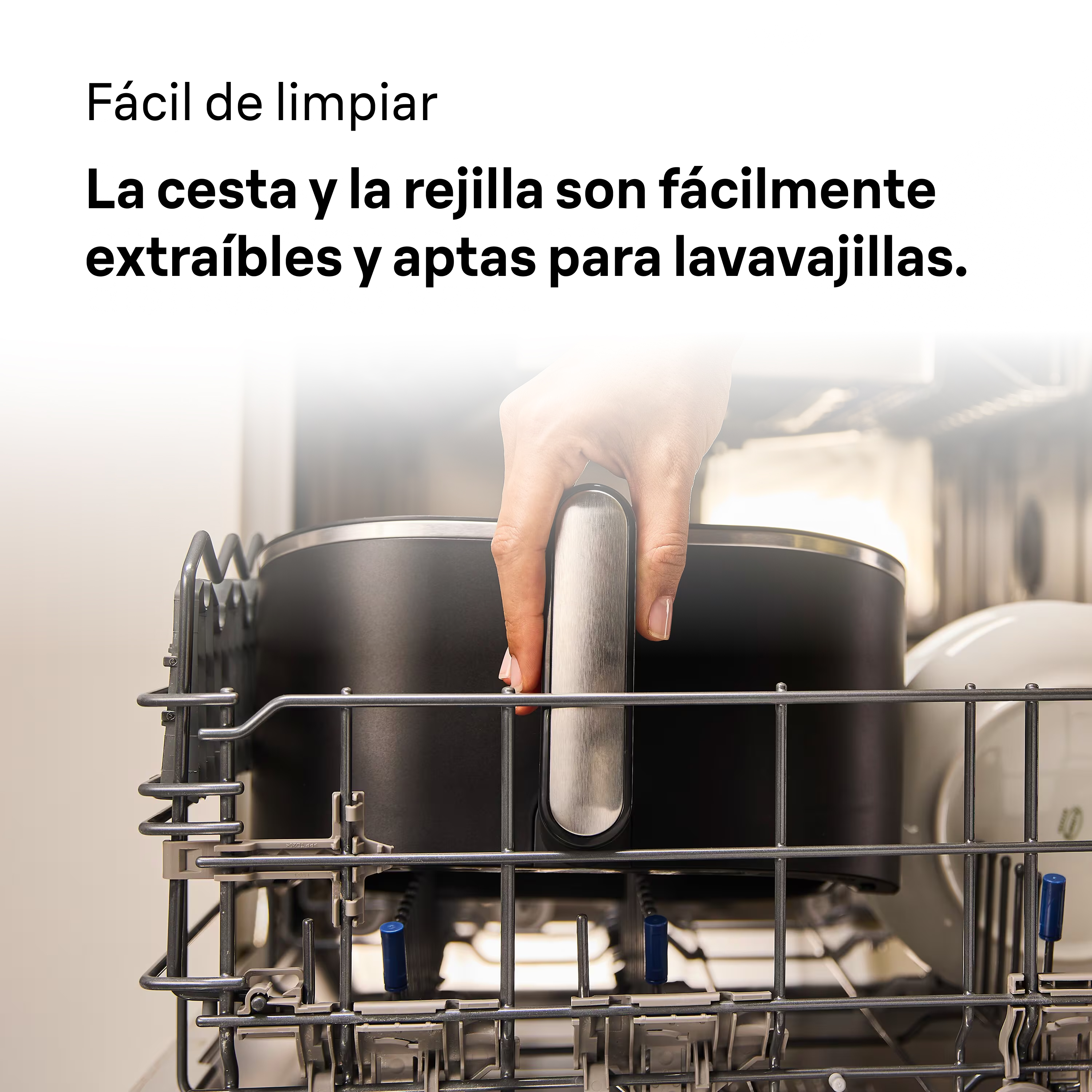 Mano sosteniendo una olla negra en un lavavajillas. La olla y la rejilla son fáciles de quitar y aptas para lavavajillas.
