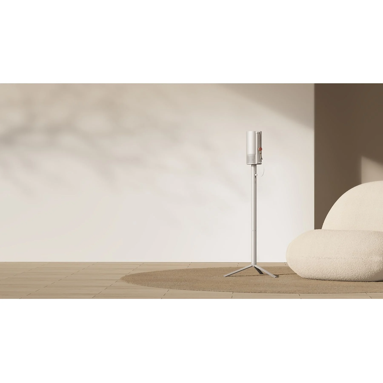 Een moderne kamer met een witte staande luchtreiniger, een beige bank en een rond tapijt op een houten vloer.