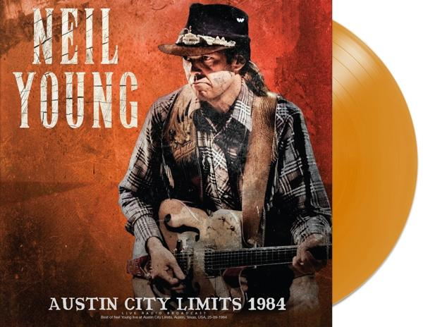 Neil Young gitárral egy lemezborítón. Kalapot és kockás inget visel. A lemez narancssárga.