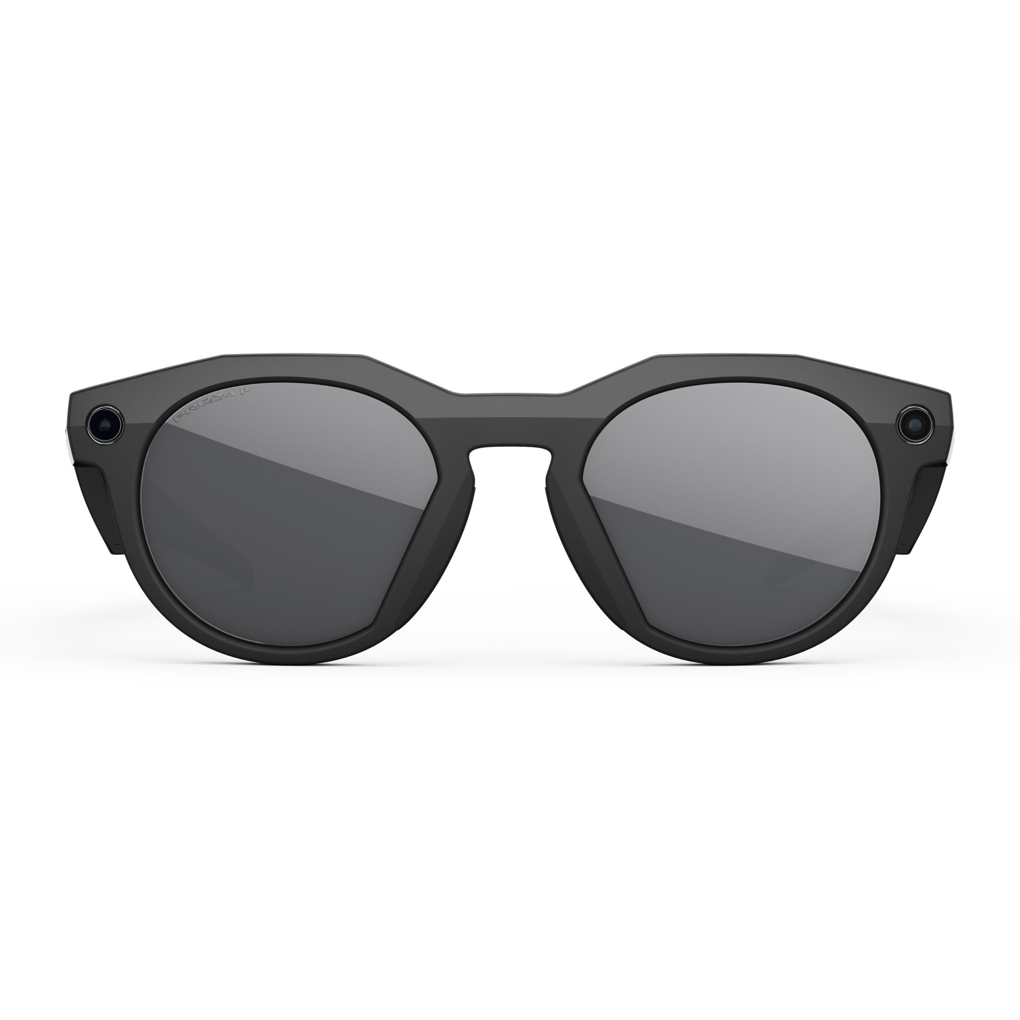 Schwarze Sonnenbrille mit grauen Gläsern und geschwungenem Design. Die Gläser reflektieren das Licht. Der Rahmen hat ein mattes Finish.