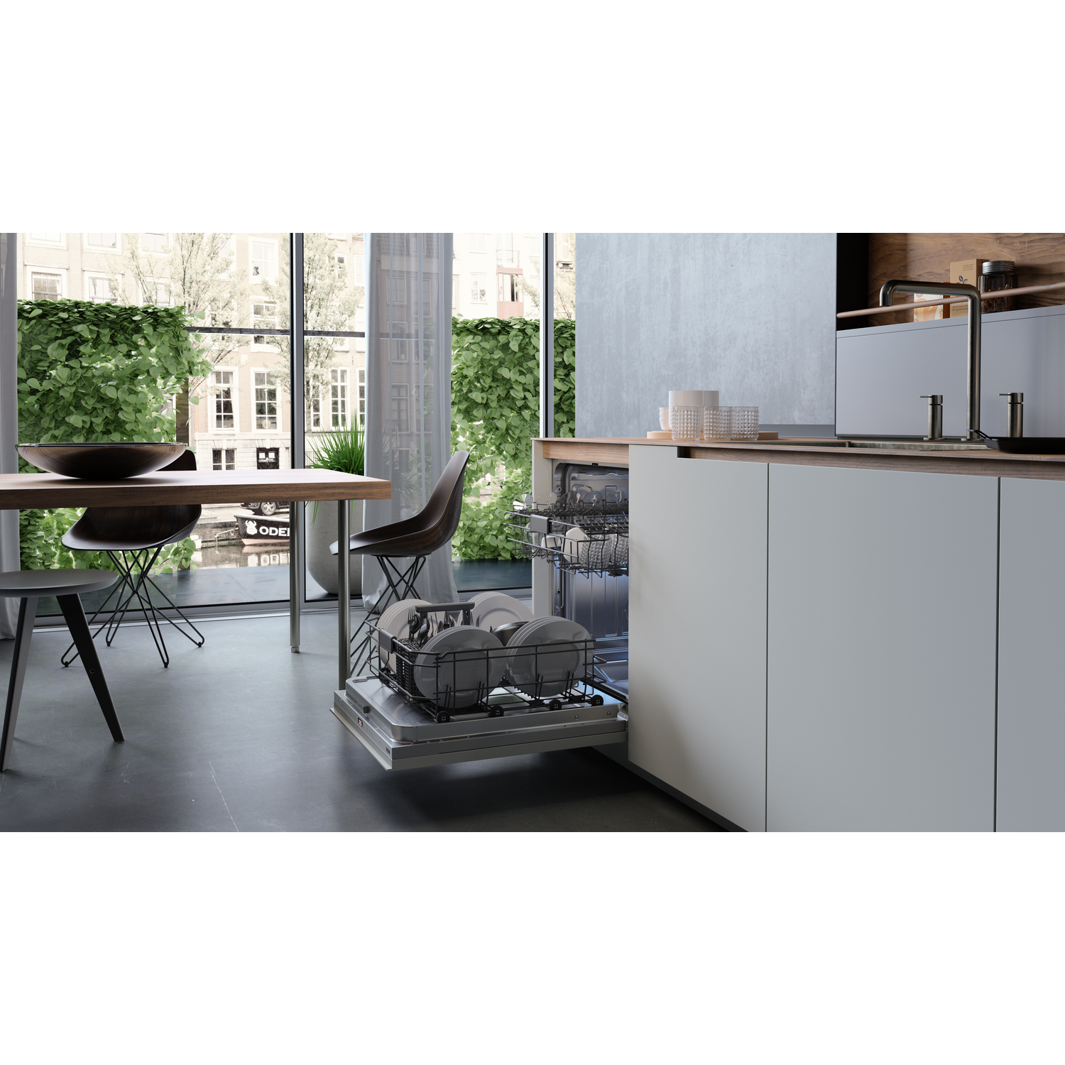Keuken met een open vaatwasser vol borden. Een tafel en stoelen voor een raam met groen.