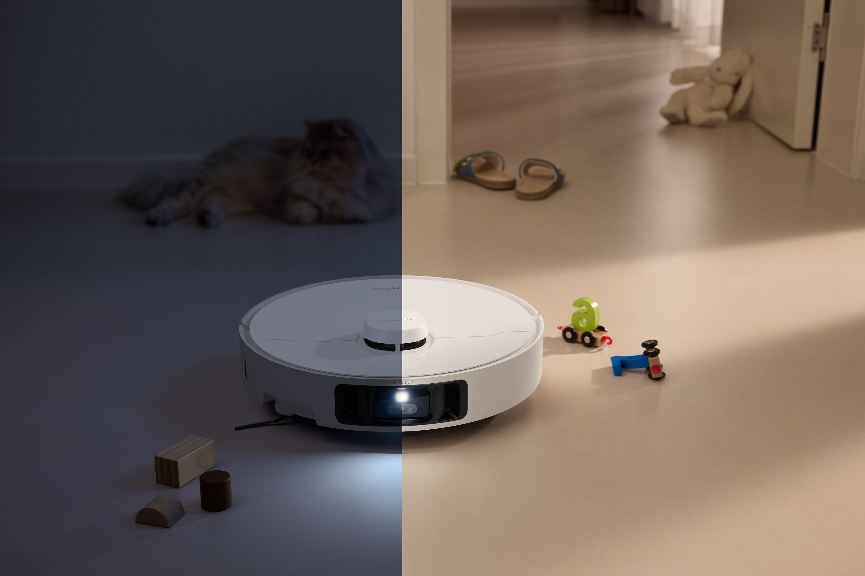 Biały robot sprzątający, zabawki, kot i sandały leżą na podłodze. Pluszowy królik opiera się o ścianę.