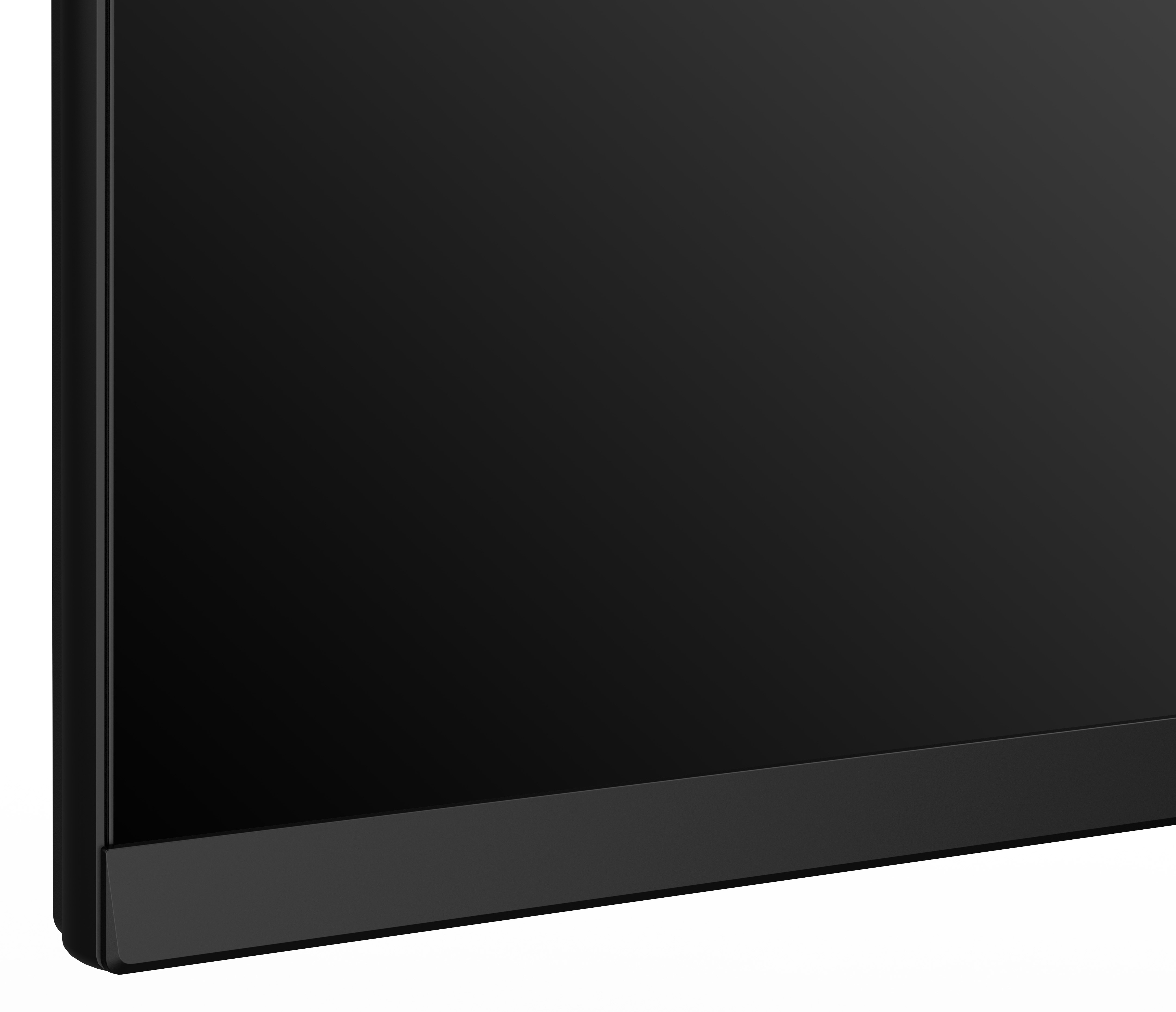 Czarny ekran z czarną ramką. Dolna ramka jest szersza. Widoczny róg. Tło jest białe.