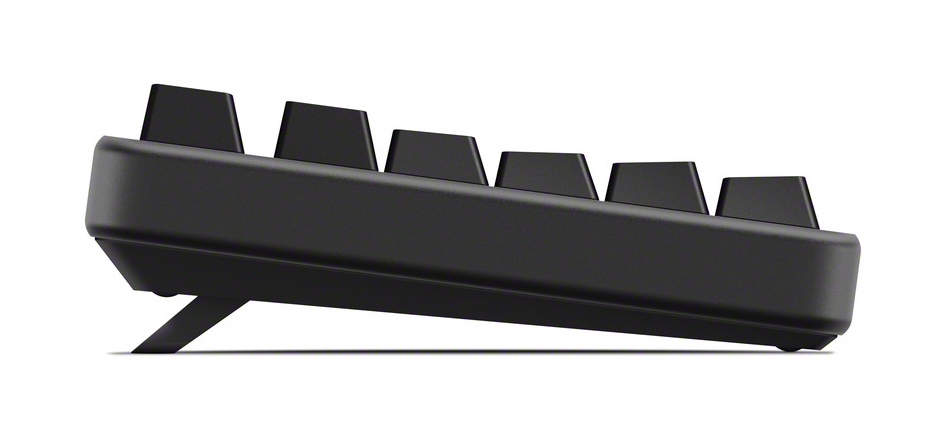Widok z boku czarnej klawiatury z sześcioma widocznymi klawiszami. Klawiatura jest podniesiona przez małą podstawkę, ustawioną pod kątem na białym tle.