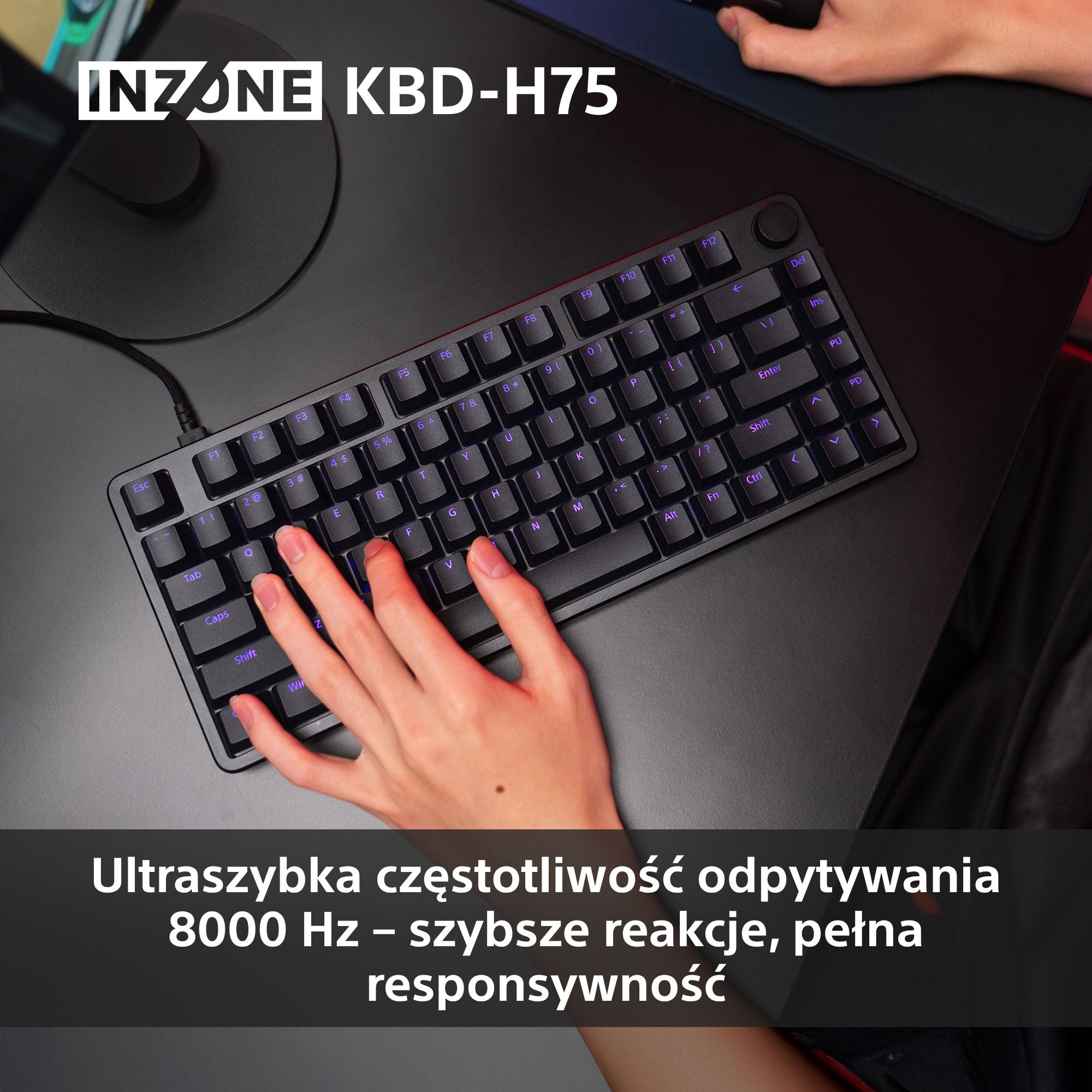 Ręka pisze na czarnej klawiaturze INZONE KBD-H75 z fioletowymi podświetlanymi klawiszami. Klawiatura leży na czarnej powierzchni.