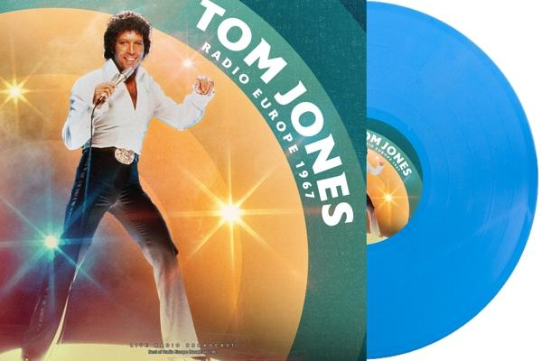 Tom Jones egy lemezborítón. Fehér inget és sötét nadrágot visel. Jobbra egy világoskék lemez látható.