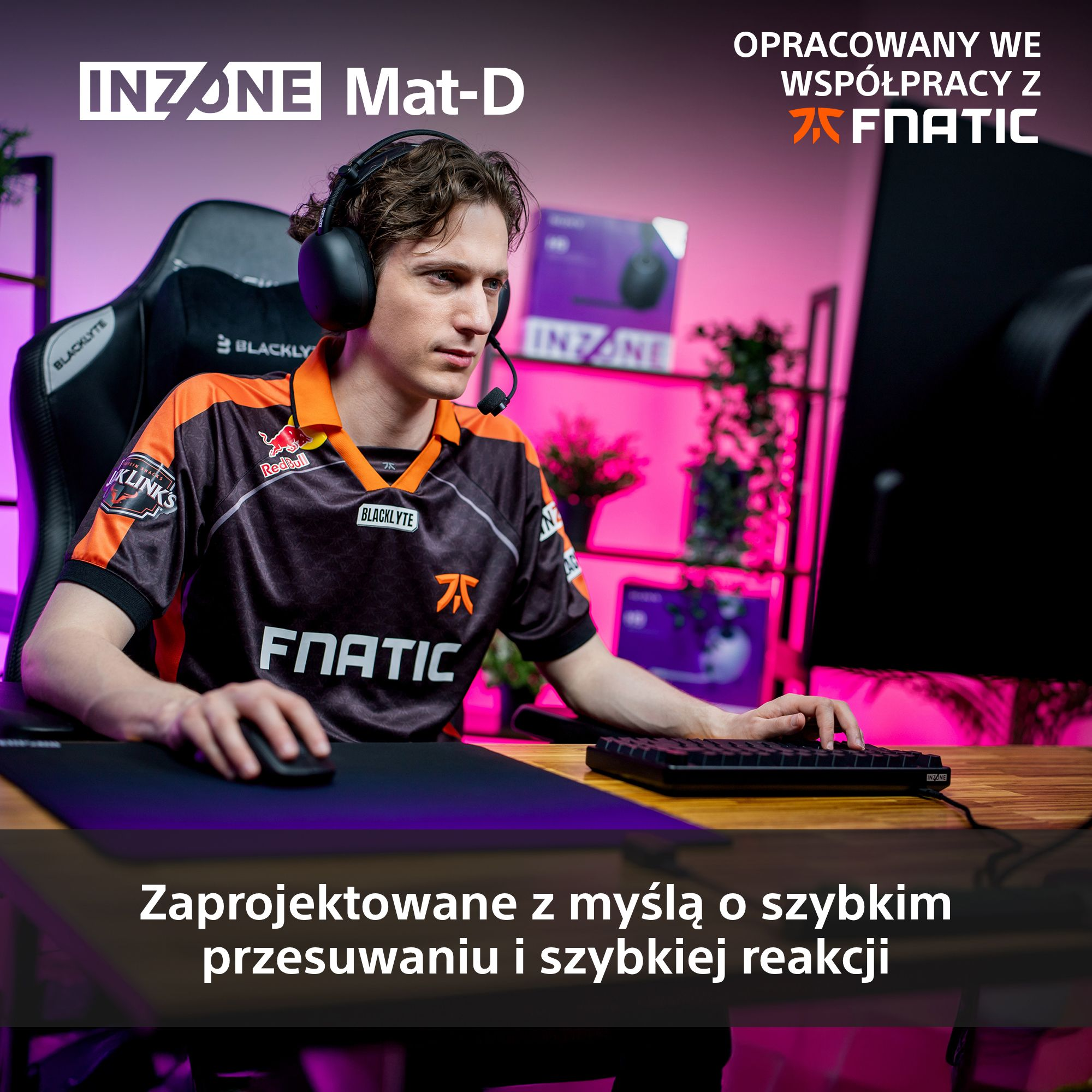 Gracz w słuchawkach pisze na klawiaturze. Ma na sobie koszulkę drużyny, siedzi w fotelu gamingowym. Scena rozgrywa się w pokoju gracza.