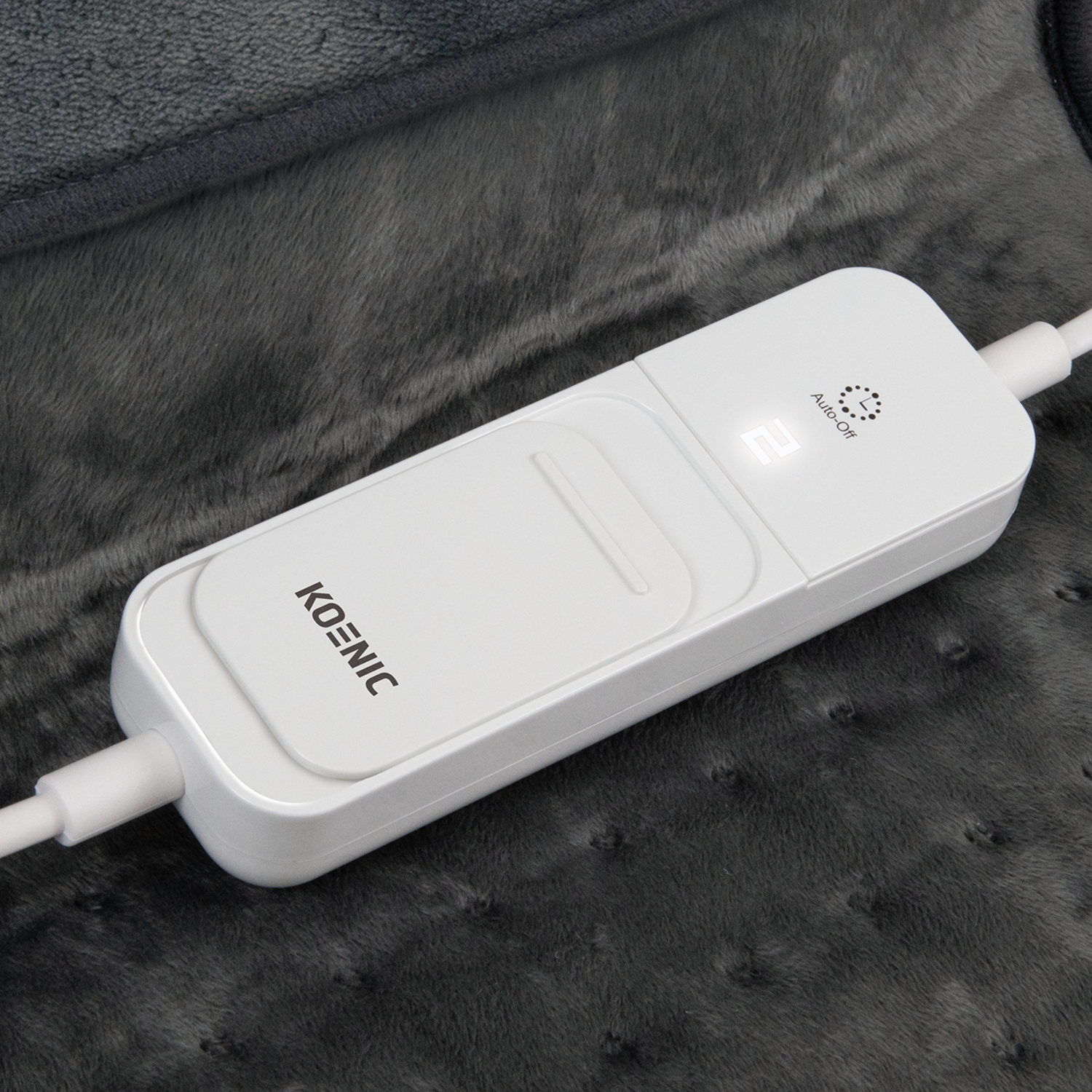 A white Koenic controller with digital display showing '2' on a dark gray heated blanket. It has an 'Auto-Off' function.