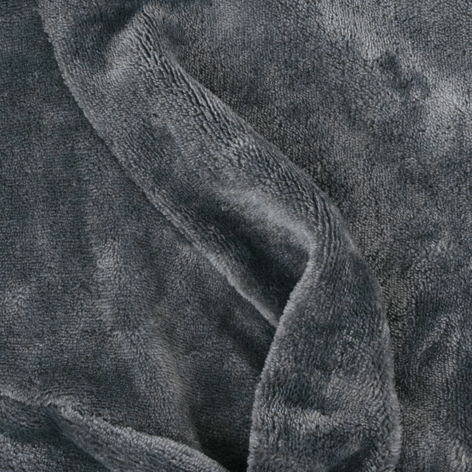 Close-up of a soft, gray blanket. The fabric is plush and has a textured surface with folds creating shadows and highlights.