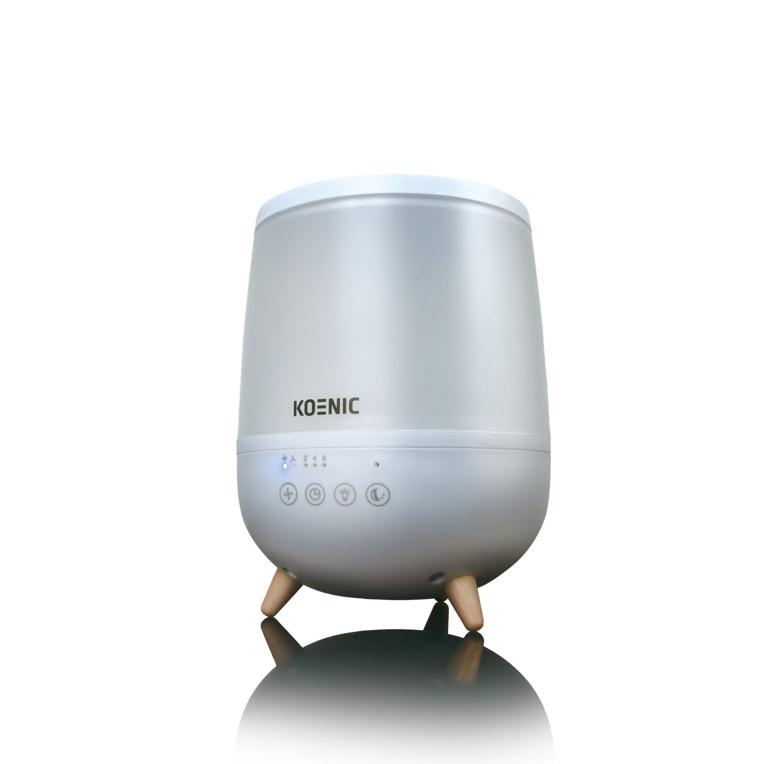 A white Koenic aroma diffuser with wooden legs. It has buttons and lights on the front. The background is black with a white reflection.