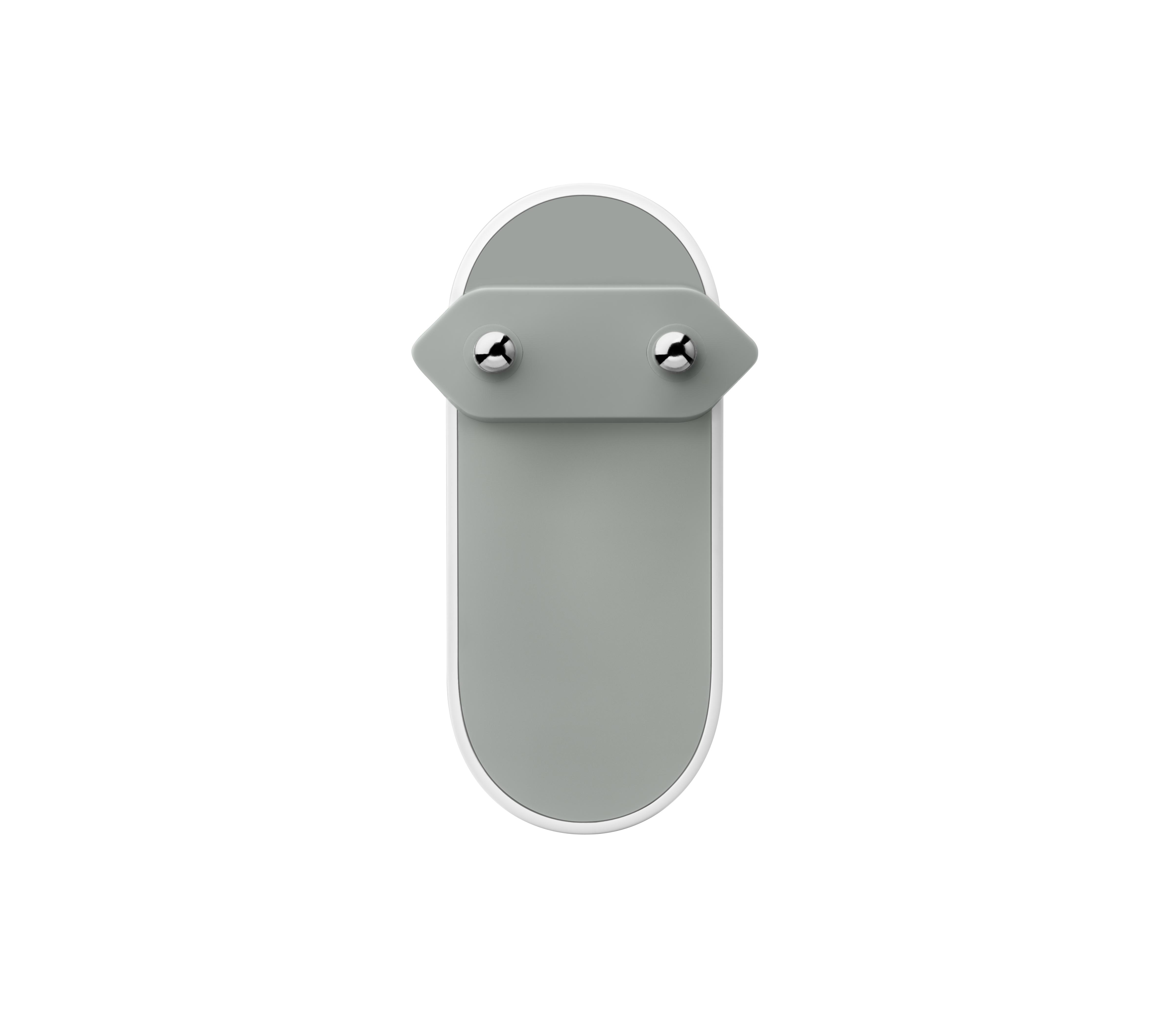 Ein graues, oval geformtes Objekt mit weißem Rand und zwei silbernen Schrauben. Der Hintergrund ist weiß.