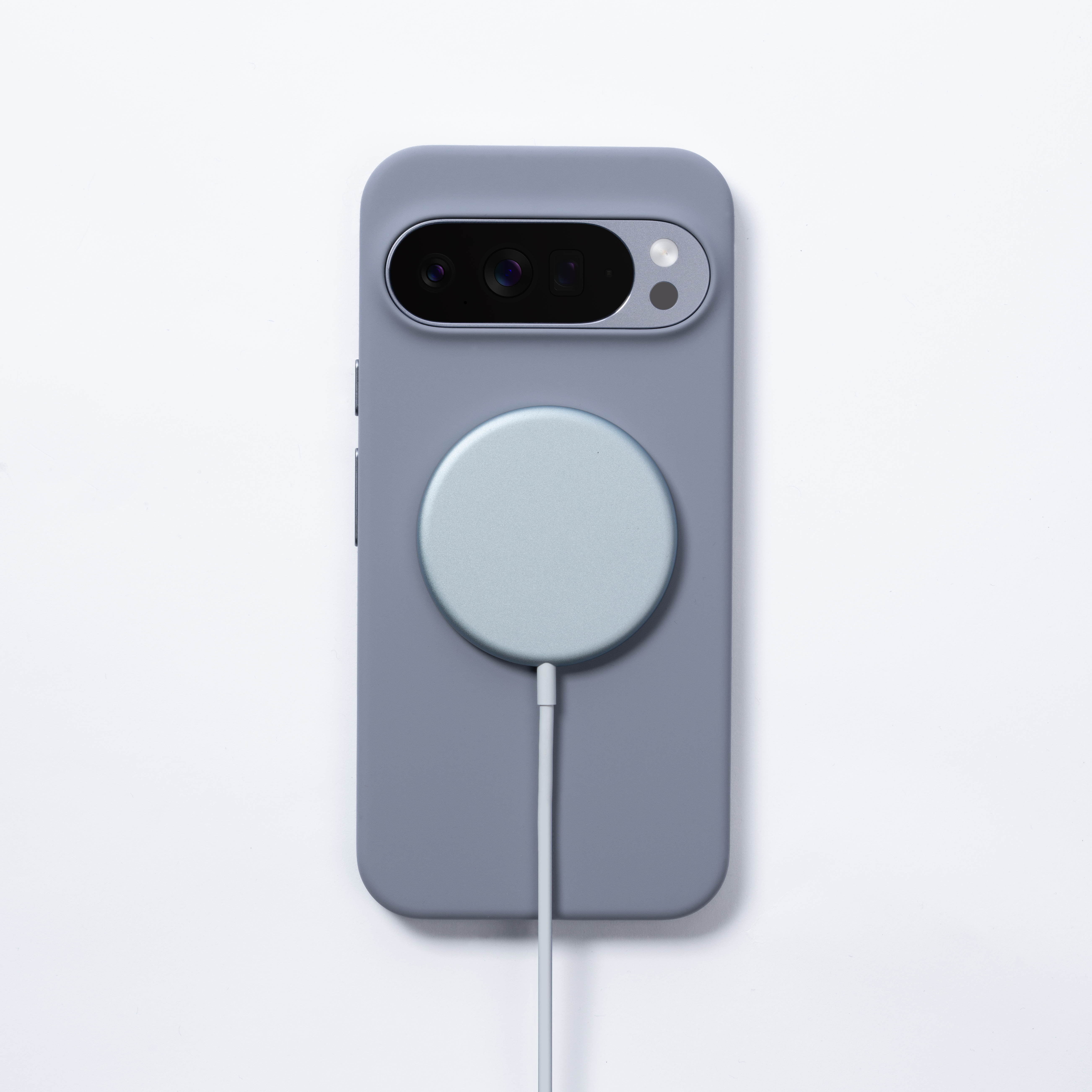 Ein Telefon in einem grauen Gehäuse mit einem kreisförmigen Ladegerät. Das Ladegerät ist mit einem weißen Kabel verbunden.