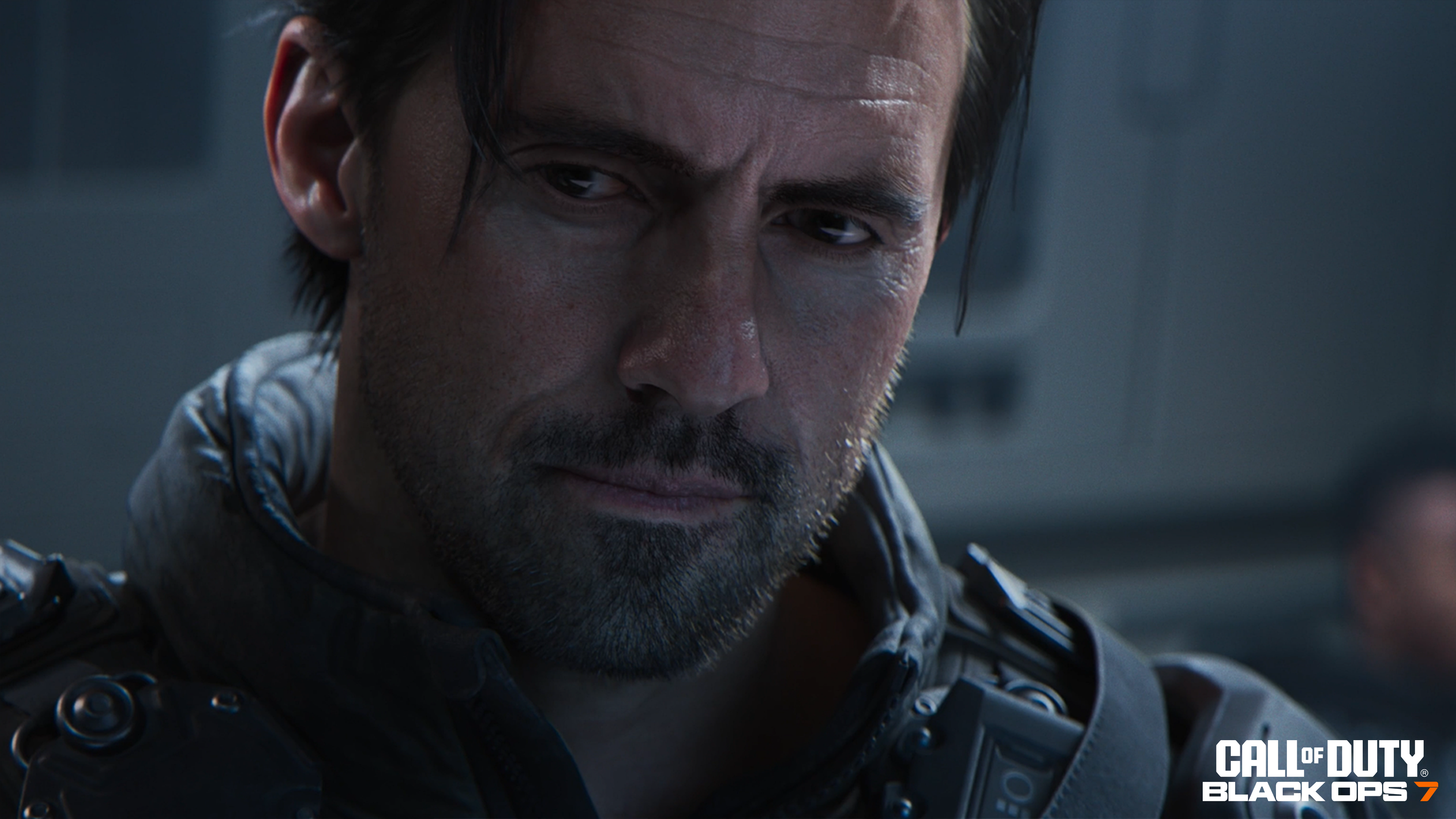 Nahaufnahme eines Mannes mit dunklem Haar und Bart, der mit ernstem Blick nach unten schaut. Das Call of Duty: Black Ops 7-Logo befindet sich unten rechts.