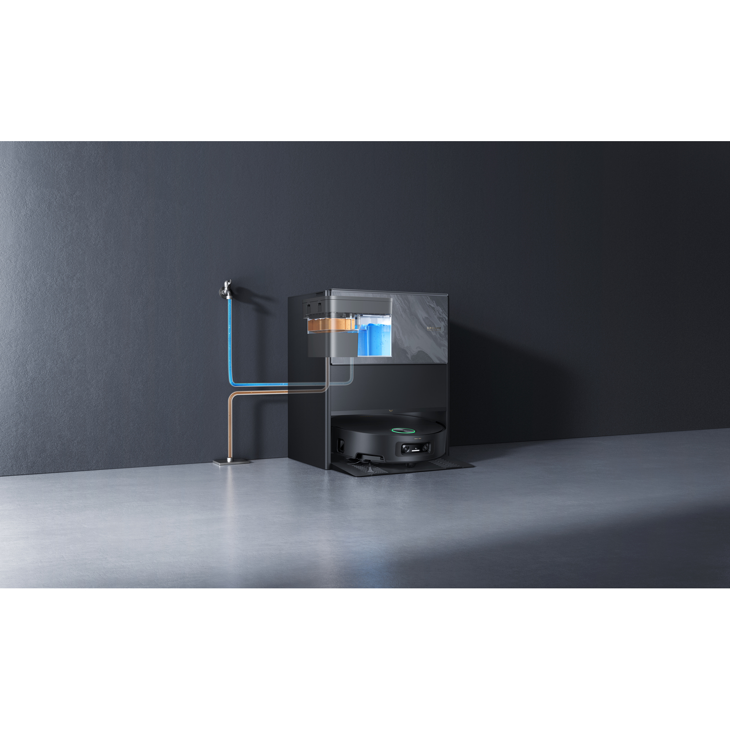 A black robot vacuum cleaner is docked in a black station. Water lines connect the station to a faucet on a gray wall.
