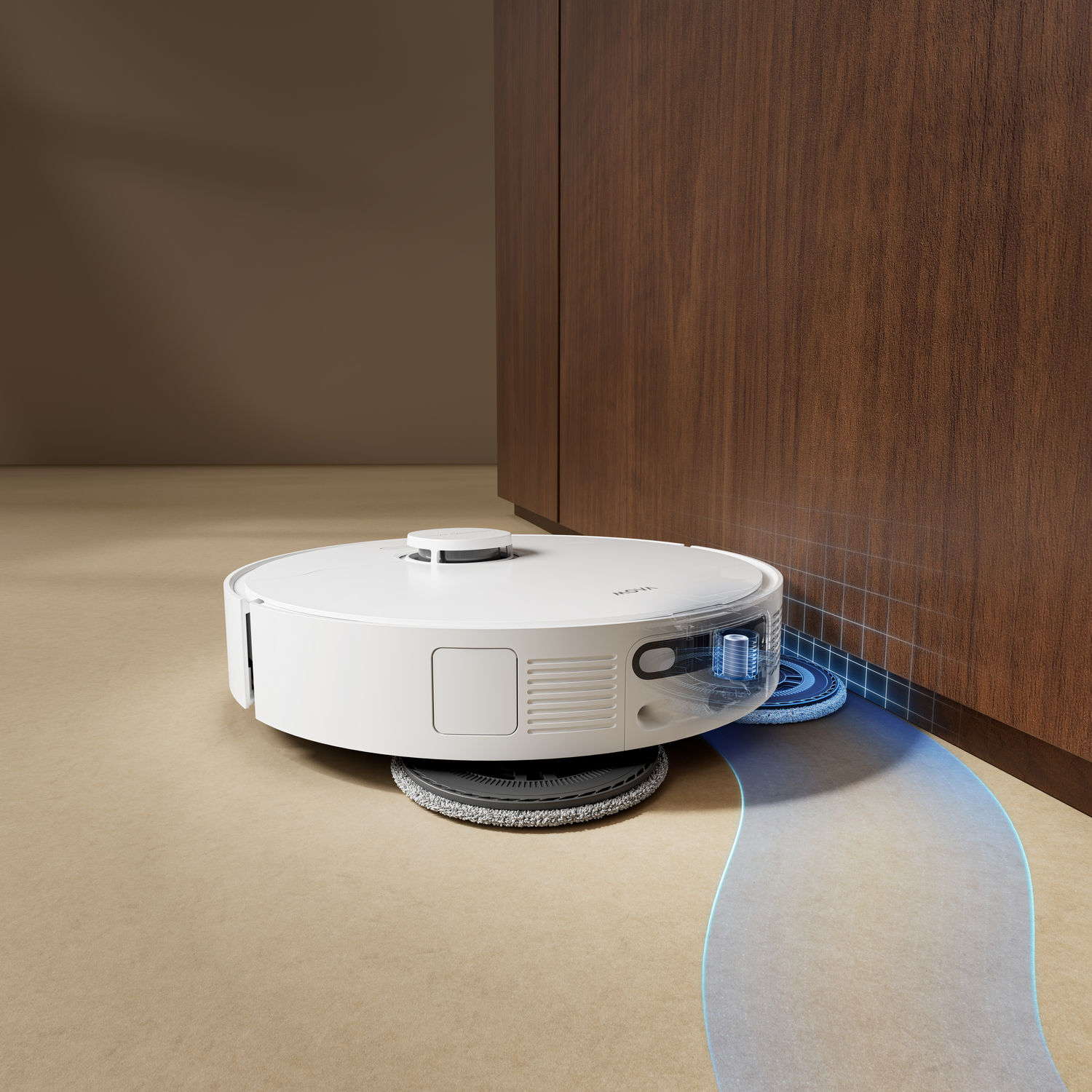 A white robot vacuum cleaner cleans a beige floor near a dark wood cabinet. A blue path shows the cleaning route.