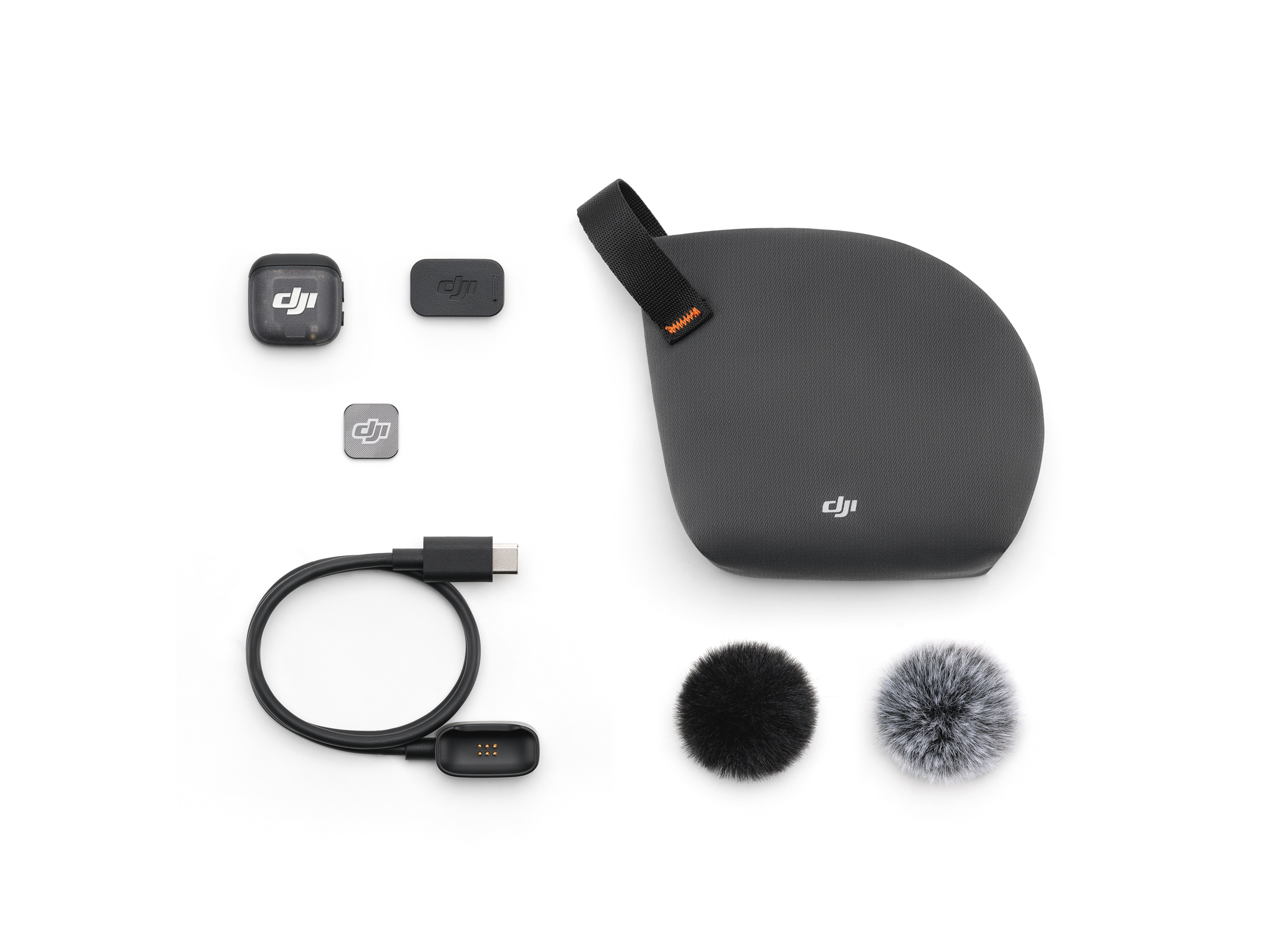 DJI-Audio-Aufnahmekit auf Weiß. Enthält Mikrofone, Gehäuse, USB-Kabel und Empfänger. Schwarz- und Grautöne.