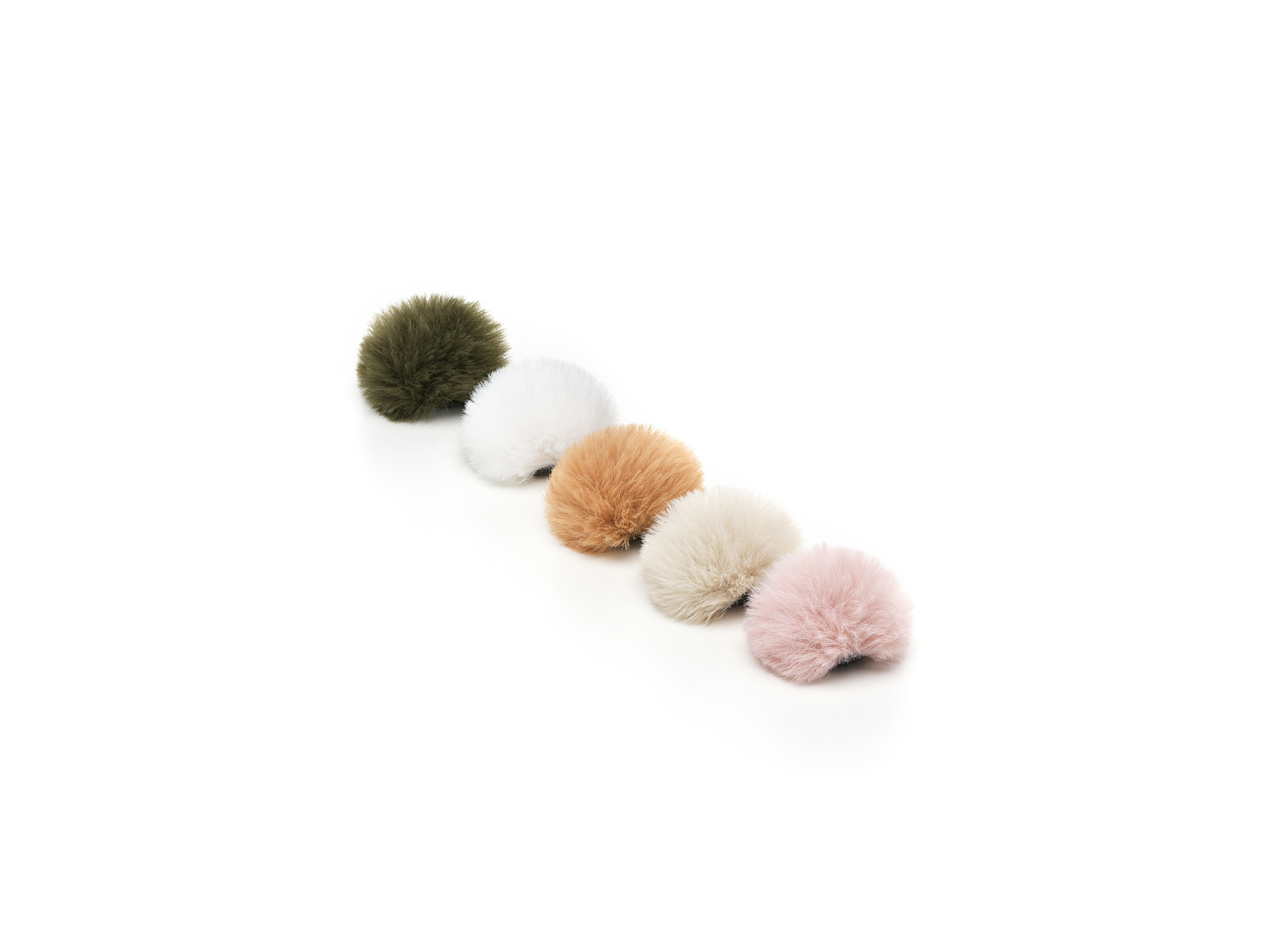 Fünf flauschige, runde Objekte in einer Reihe. Farben sind Grün, Weiß, Hellbraun, Off-White und Rosa, vor weißem Hintergrund.