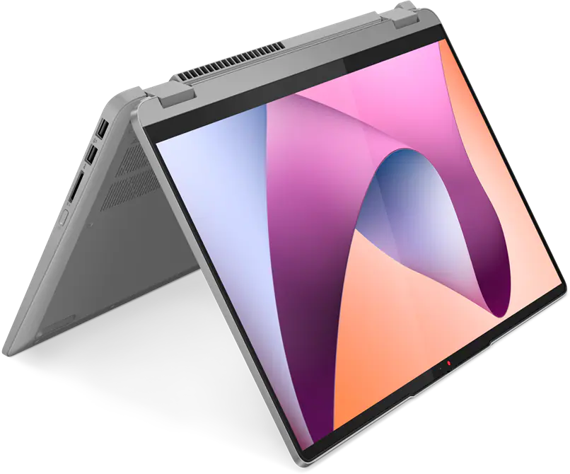 Egy szürke laptop nyitva van. A képernyő absztrakt rózsaszín, narancssárga és kék formákat jelenít meg. Fekete háttér.