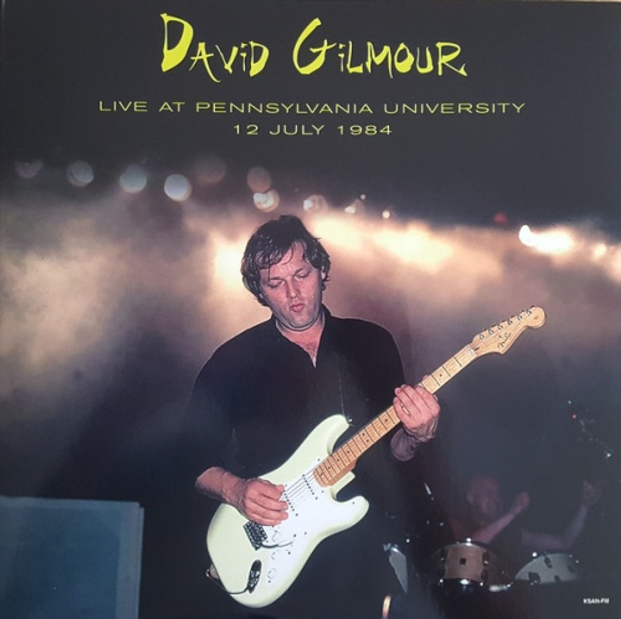 David Gilmour gitározik élőben a Pennsylvania University-n, 1984. július 12-én. Fekete ruhában van, fehér gitárt tart.
