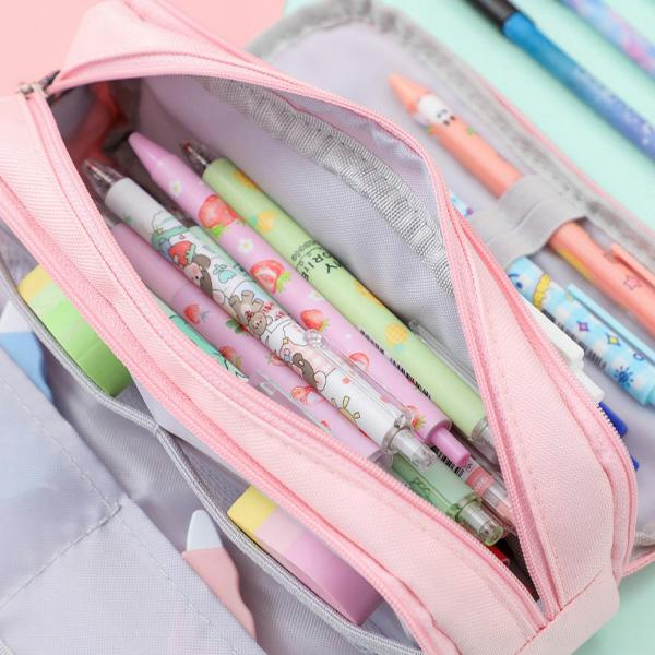 Różowe piórnik wypełniony długopisami, gumkami i karteczkami samoprzylepnymi. Długopisy są różowe, zielone i niebieskie, z różnymi wzorami.