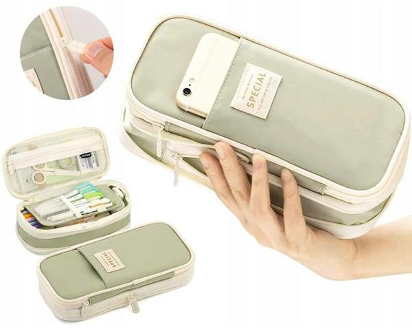 Ręka trzyma szare piórnik z telefonem w kieszeni. Inny otwarty piórnik pokazuje długopisy i nożyczki. Trzeci leży poniżej.