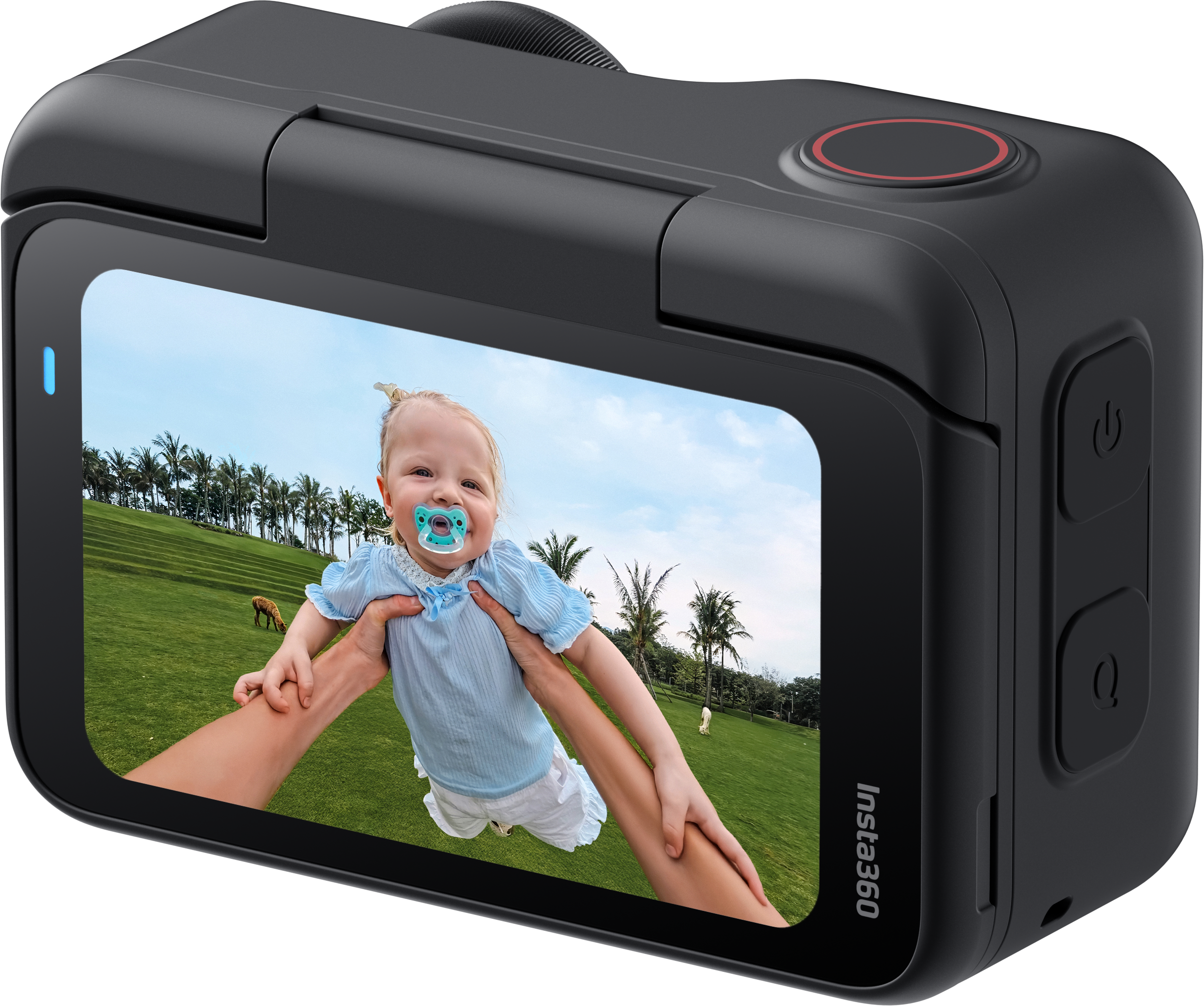 Ein Baby wird auf einem Feld in die Höhe gehalten. Das Baby trägt einen Schnuller und ein blaues Hemd. Eine Insta360-Kamera zeigt die Szene.