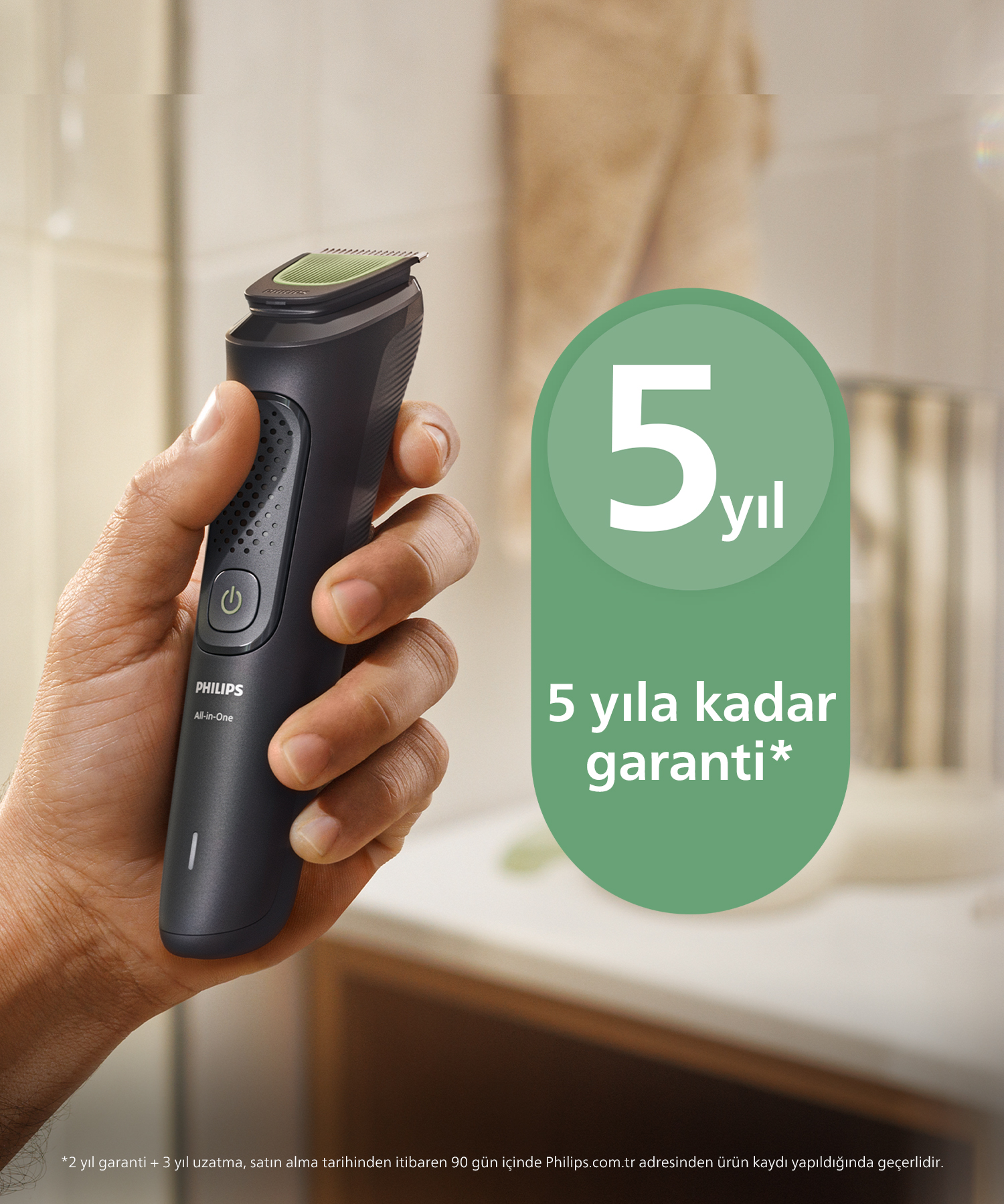 Bir el, siyah bir Philips All-in-One tıraş makinesi tutuyor. Yeşil bir oval 5 yıl garanti belirtir. Arka plan banyo.