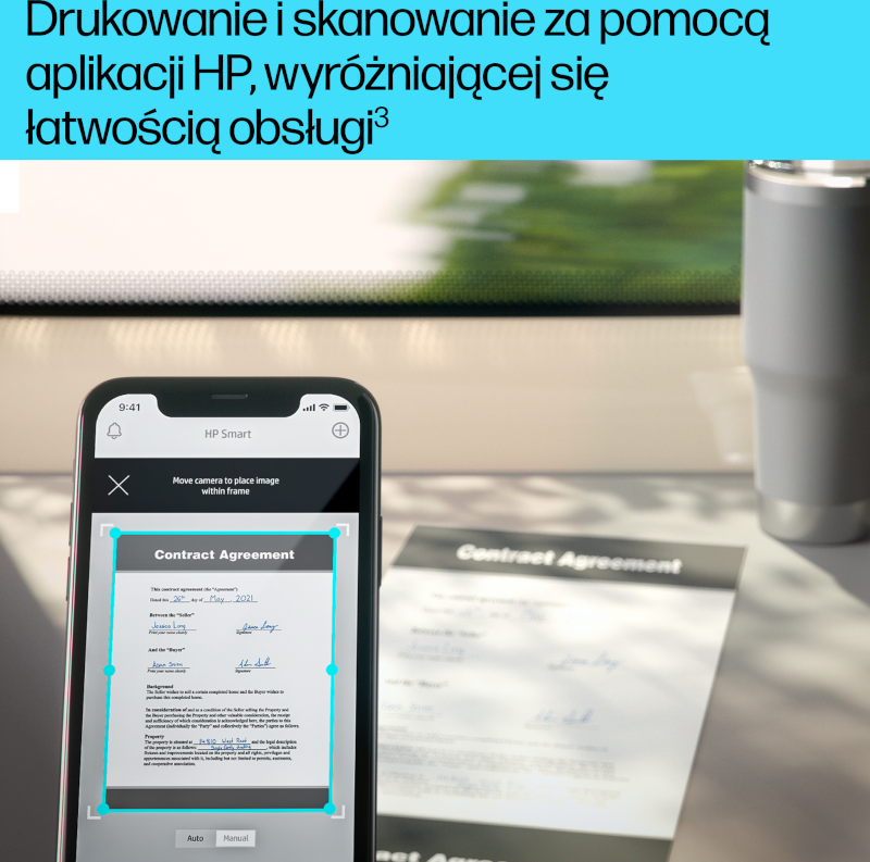 Smartfon skanuje dokument. Umowa jest widoczna na ekranie. Szary kubek stoi na biurku.