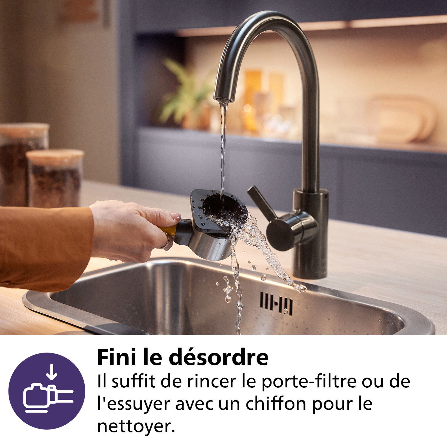 Een persoon spoelt een koffiezetapparaatfilter af onder een keukenkraan. Water spuit in een roestvrijstalen spoelbak. Koffiebonen op de achtergrond.