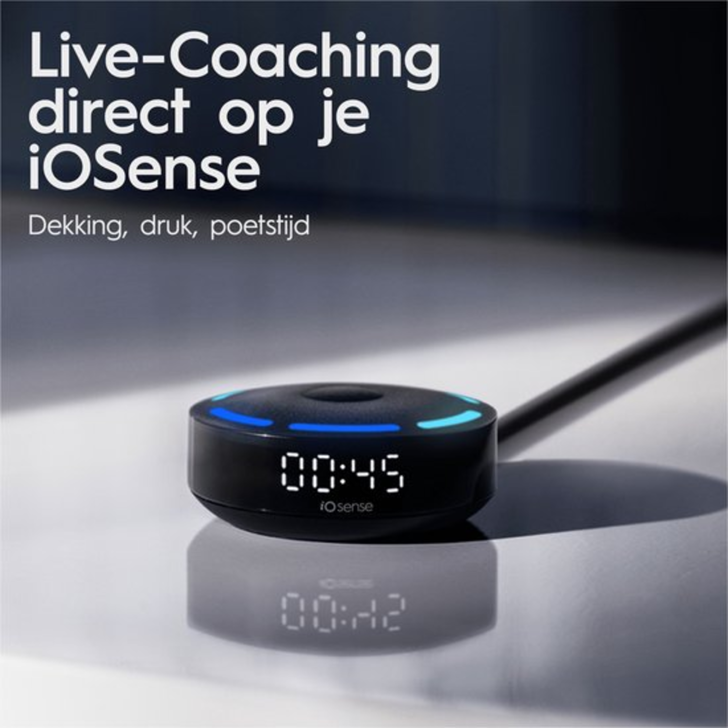 Un appareil iOsense noir affiche l'heure 00:45. L'appareil a une lumière bleue. Le reflet indique l'heure 00:42.