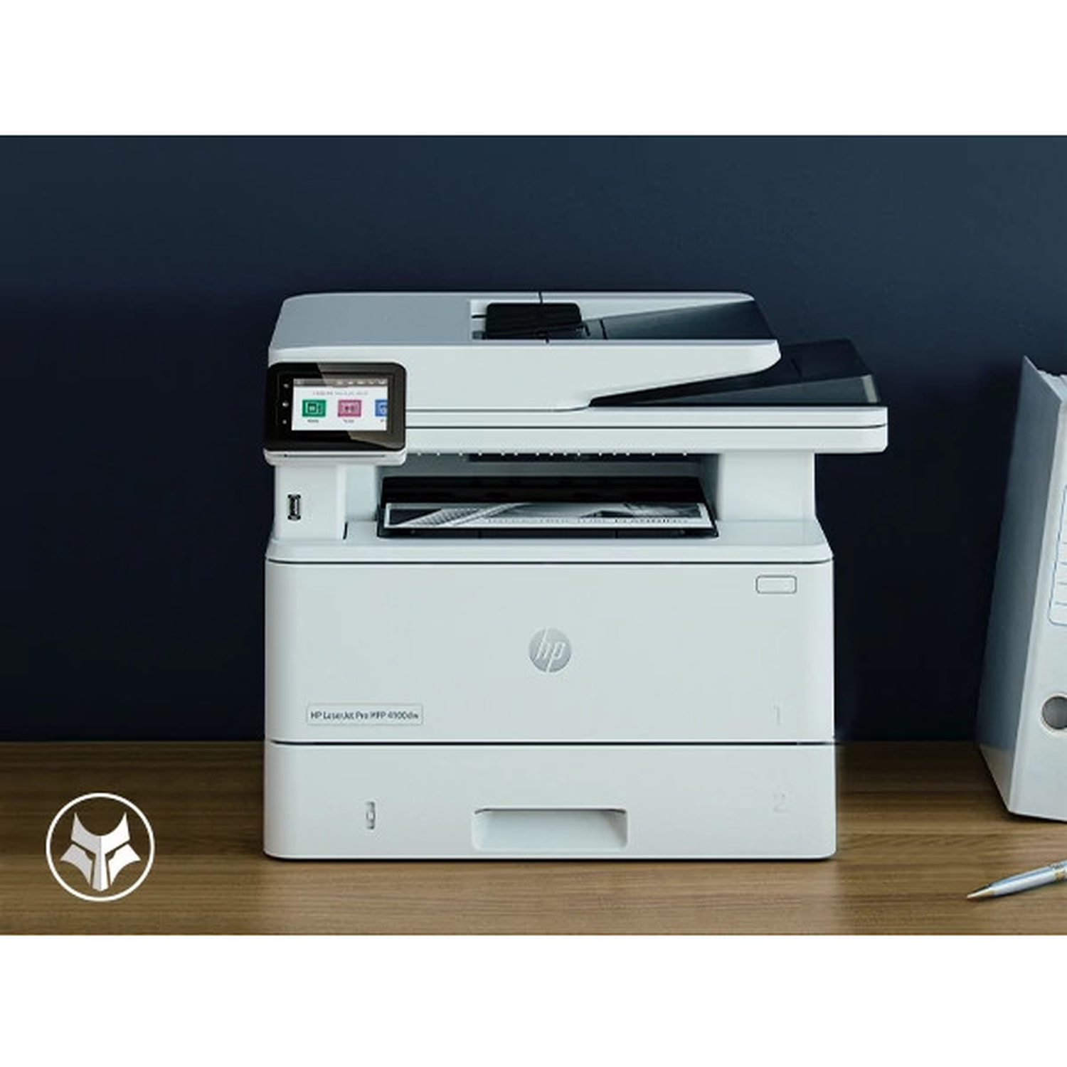 Een witte HP LaserJet printer op een houten bureau. De achtergrond is een donkerblauwe muur, met een zilveren pen en een ordner.