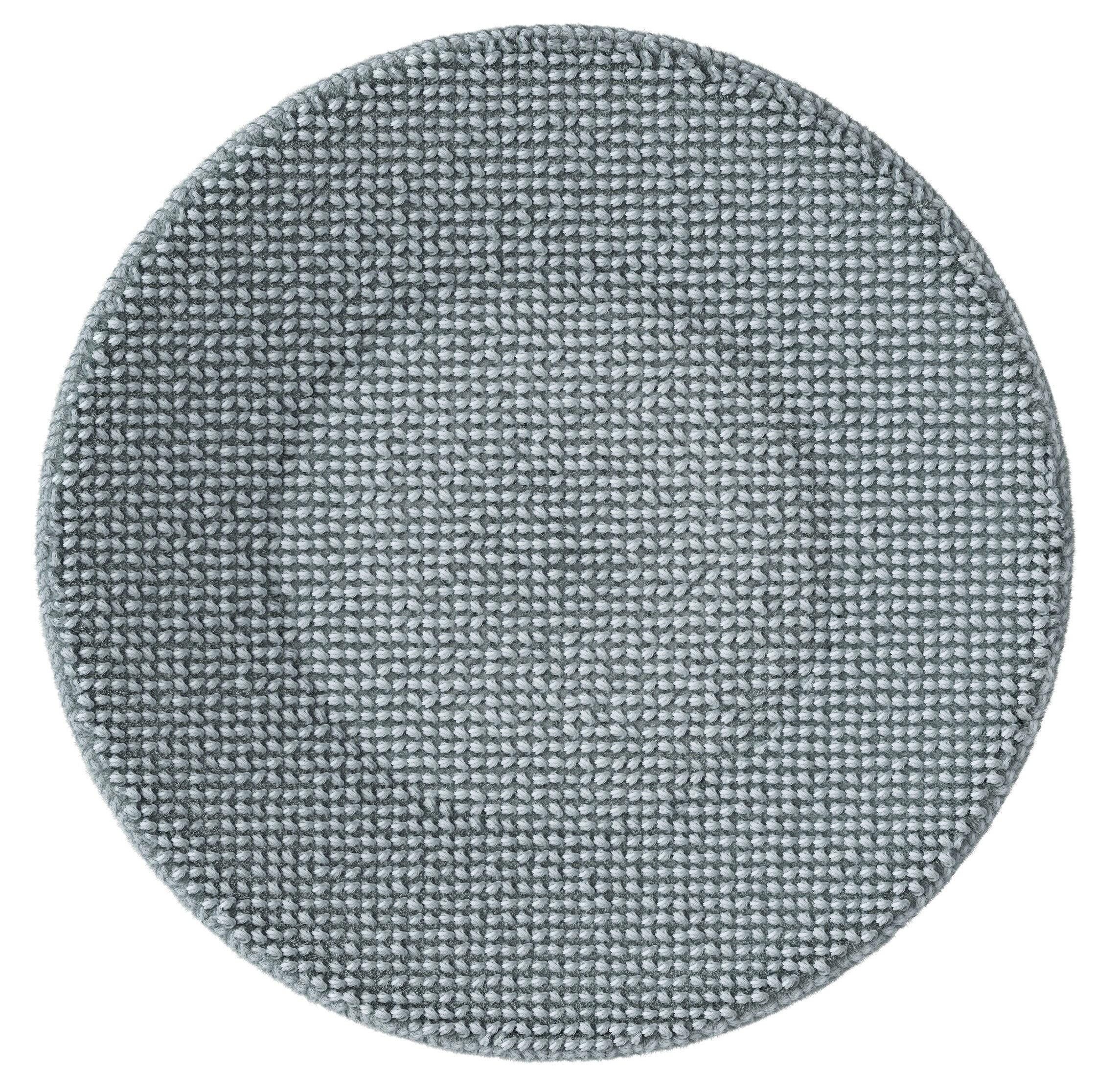 Okrągły, jasnoszary dywan o teksturowanej powierzchni, złożonej z małych, ciasno upakowanych pętelek.