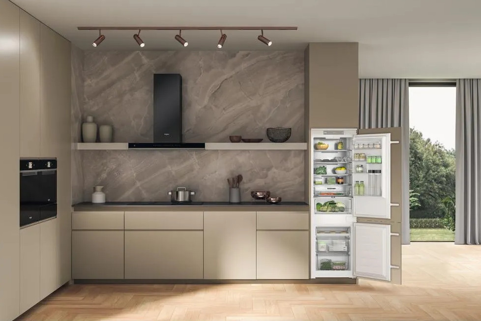 Nowoczesna kuchnia z otwartą lodówką. Kuchnia ma marmurową ścianę tylną, czarne urządzenia i neutralne szafki.