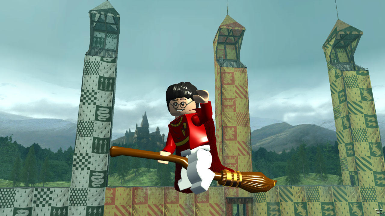 Lego Harry Potter leci na miotle w meczu Quidditcha. Wieże z flagami i zamek Hogwart w tle.