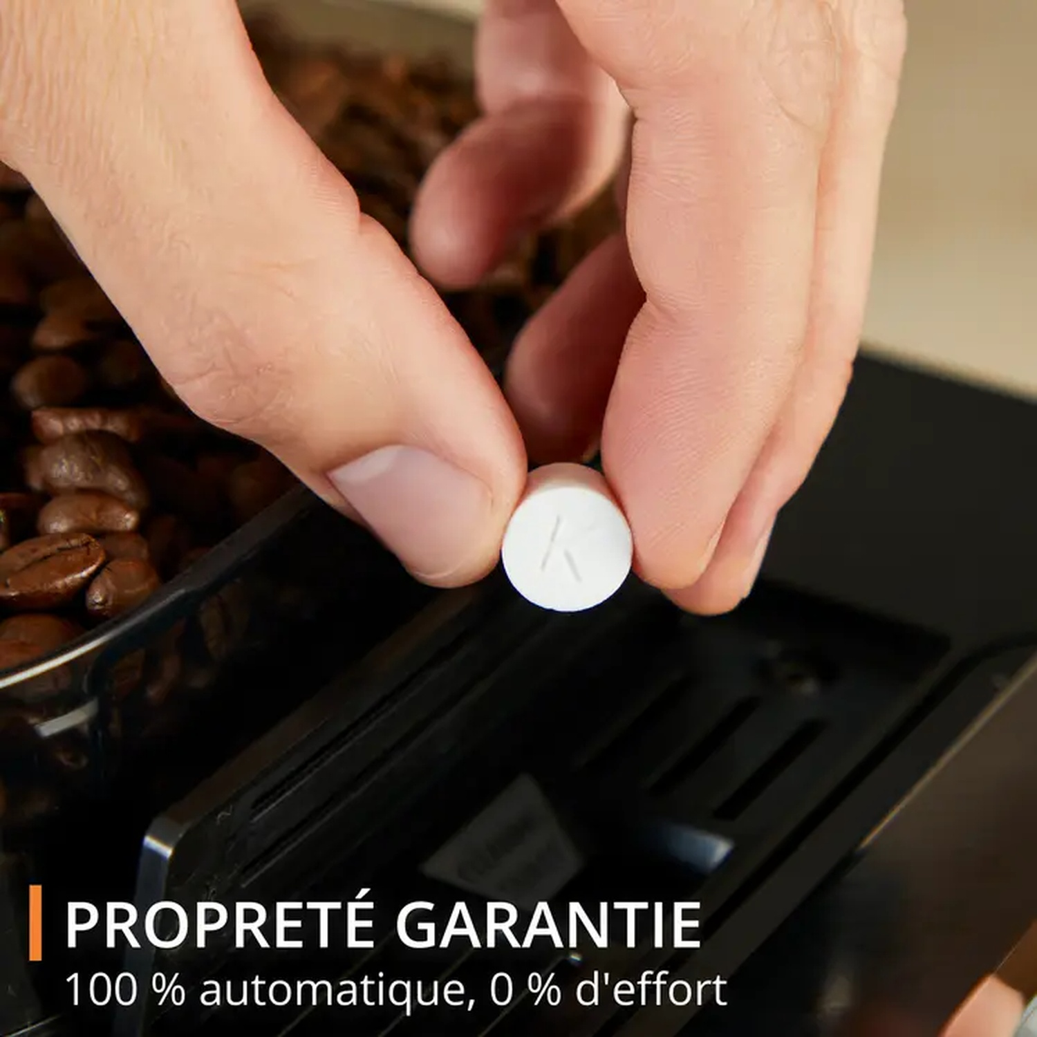 Une main tient un comprimé blanc avec un 'K'. À côté, grains de café et une machine à café noire. Texte : 'PROPRETÉ GARANTIE'.