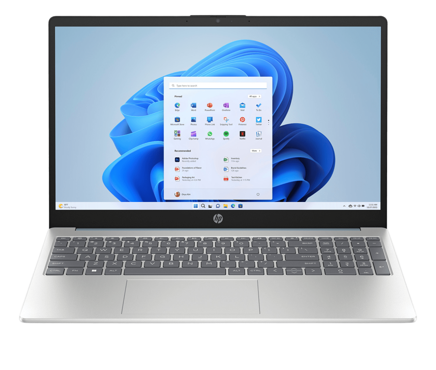 Laptop HP plateado abierto, pantalla de Windows 11 visible. La pantalla muestra iconos de aplicaciones y una barra de búsqueda.