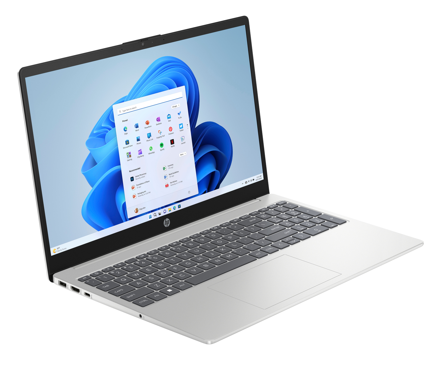 Laptop HP plateado abierto, mostrando interfaz Windows 11. Pantalla muestra iconos de aplicaciones y fondo azul abstracto.