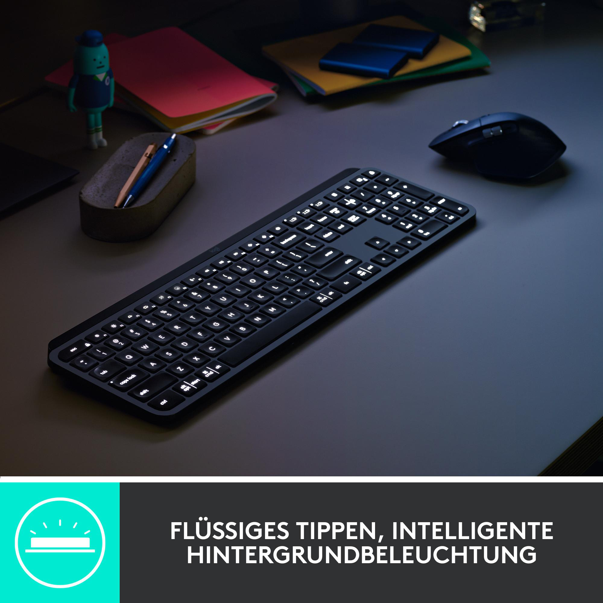 Eine Tastatur mit Hintergrundbeleuchtung auf einem Schreibtisch. Eine Maus und ein Spielzeug sind im Hintergrund.