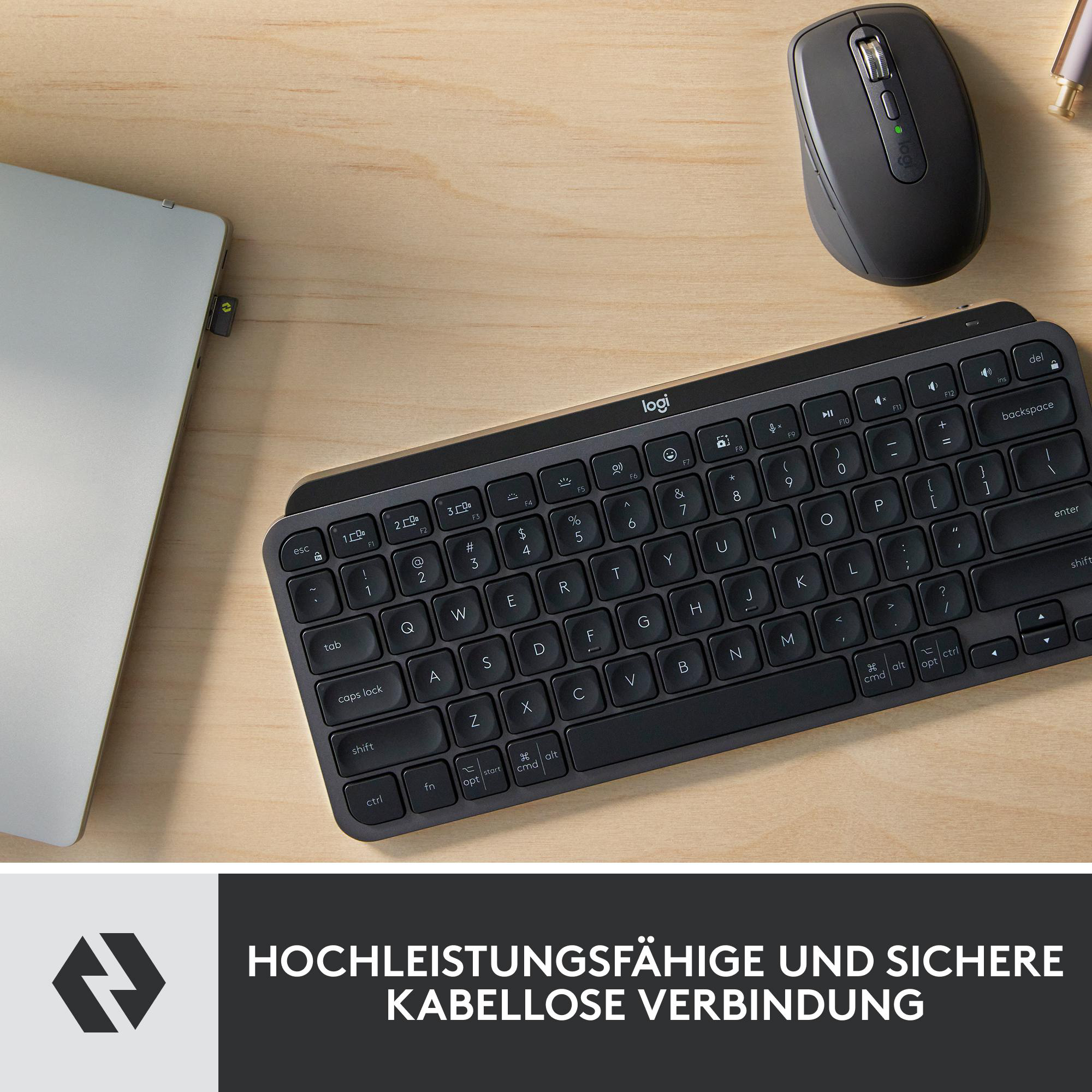 Eine schwarze Tastatur, Maus und ein Laptop auf einer Holzoberfläche. Die Tastatur hat das Logitech-Logo.