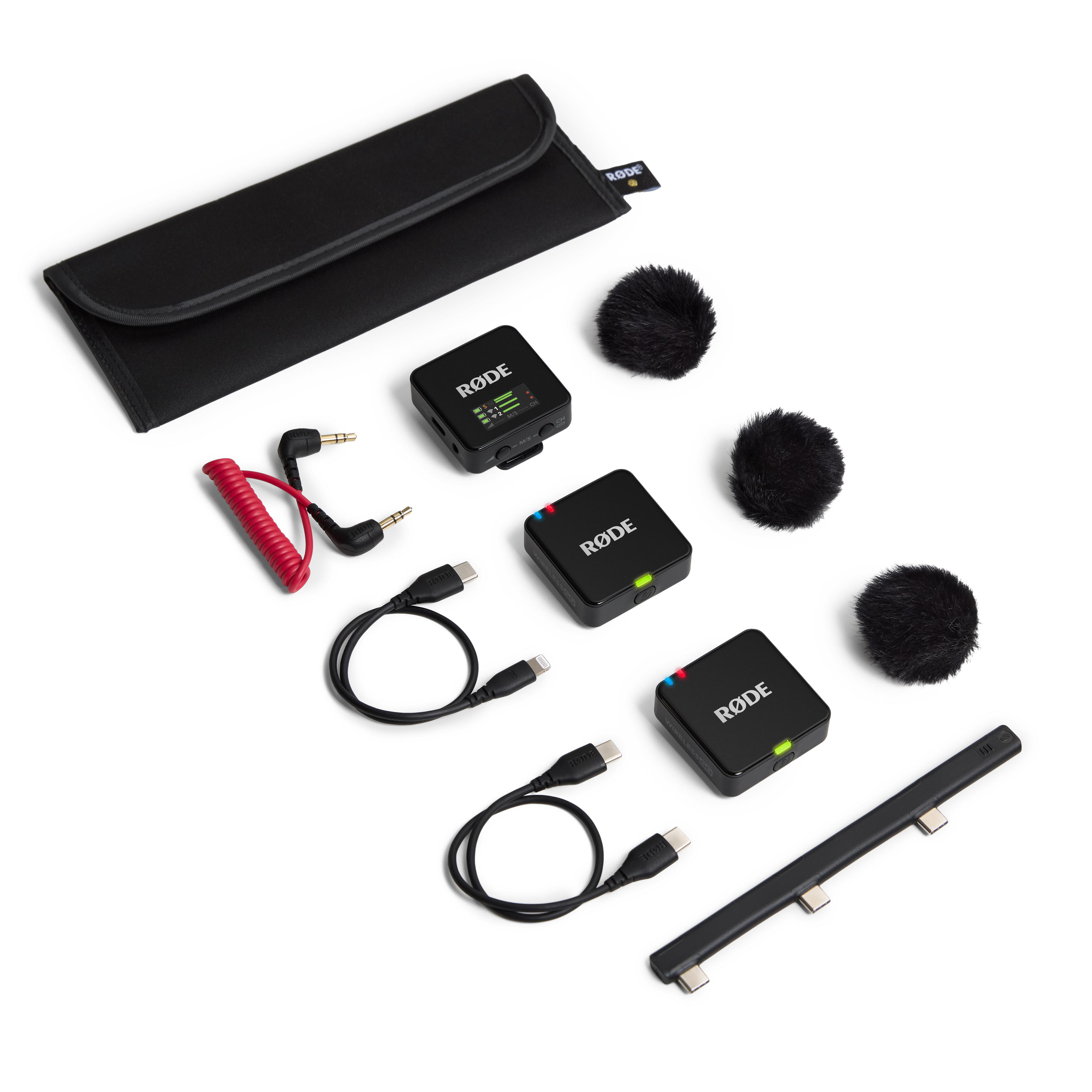 Draufsicht auf ein RØDE-Funkmikrofon-Kit. Es enthält schwarze Mikrofoneinheiten, Kabel, Windschutz und eine Tragetasche.
