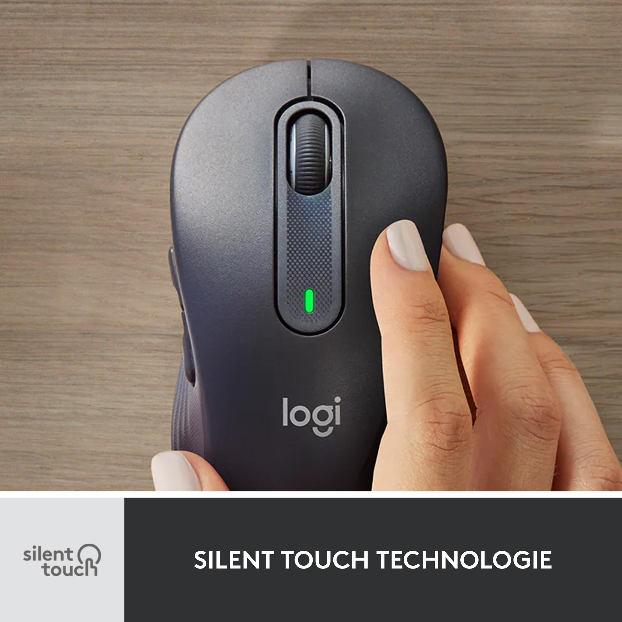 Eine schwarze Logitech-Maus mit einer Hand darauf. Das grüne Licht ist an, der Hintergrund ist Holz.