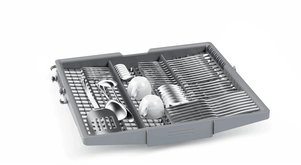 Bandeja de lavavajillas llena de cubiertos, cucharas, tazas y una espátula. Bandeja gris sobre fondo blanco.
