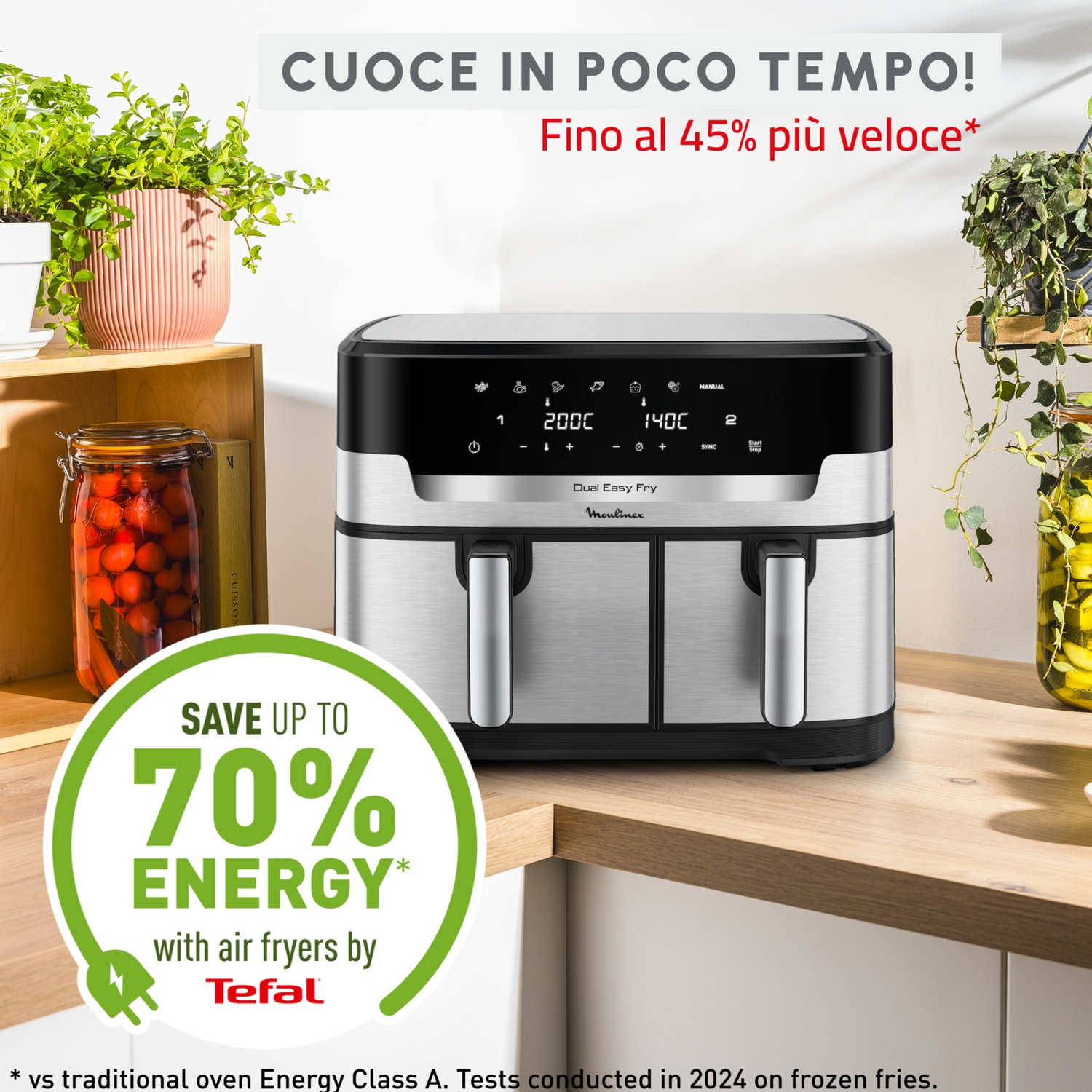 Una friggitrice ad aria con display digitale, posizionata su un bancone di legno. Ci sono piante e barattoli sullo sfondo. Testo: Risparmia fino al 70% di energia.