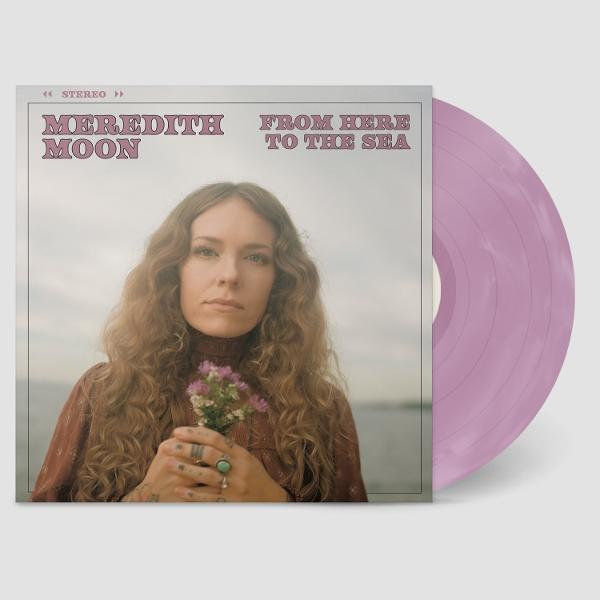 Albumcover mit einer Frau, die Blumen hält. Titel: 'Meredith Moon From Here To The Sea'. Eine lila Vinyl-Schallplatte ist sichtbar.